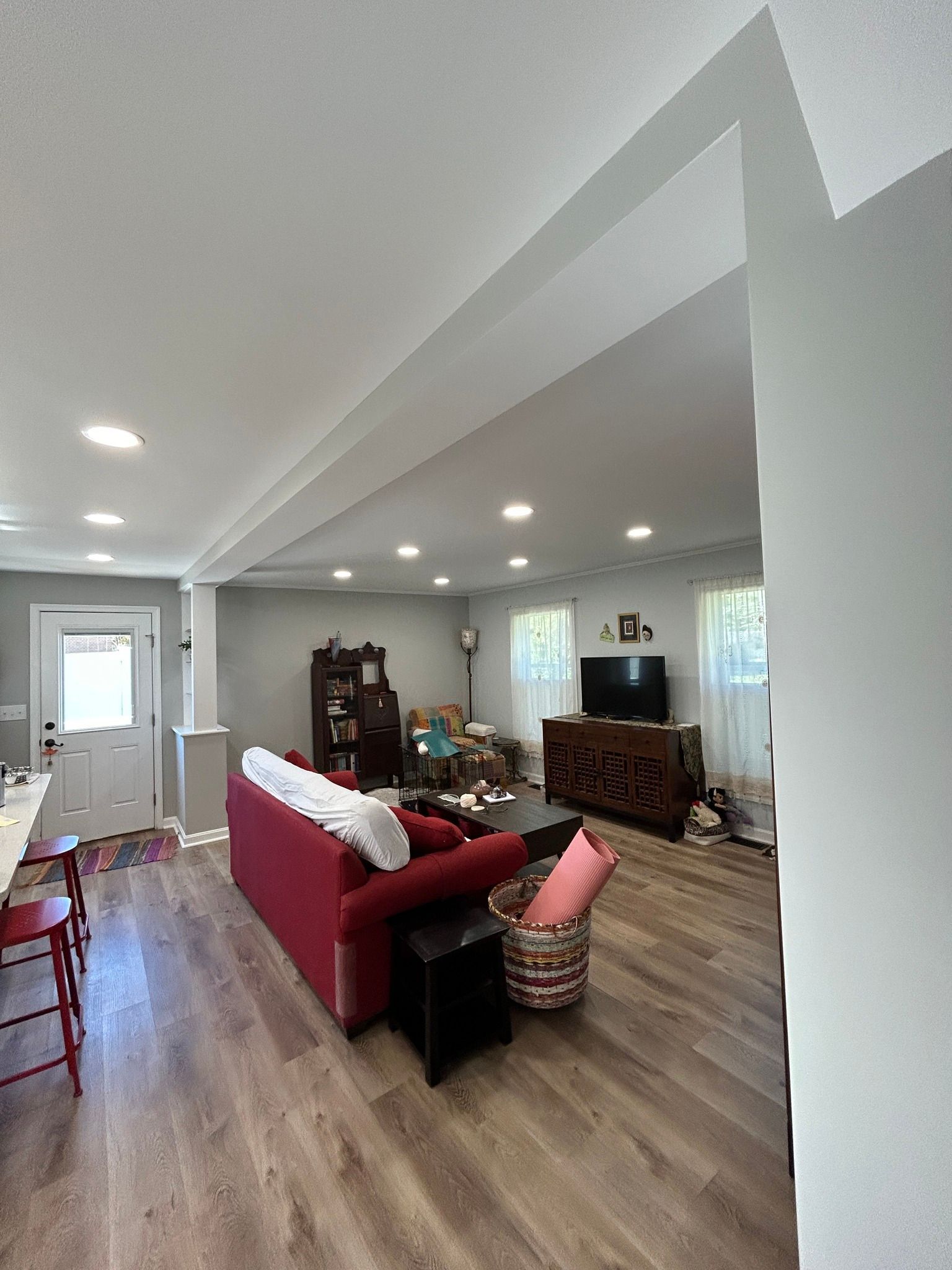 A living room with a red couch and a television.