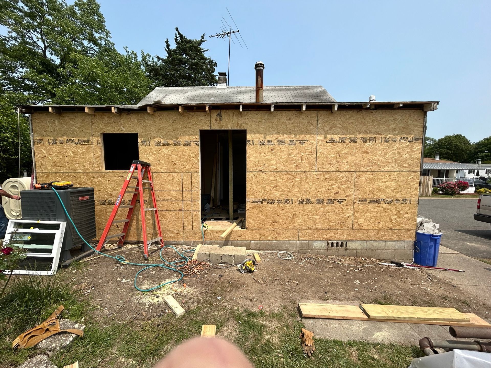 A person is standing in front of a house that is being built.