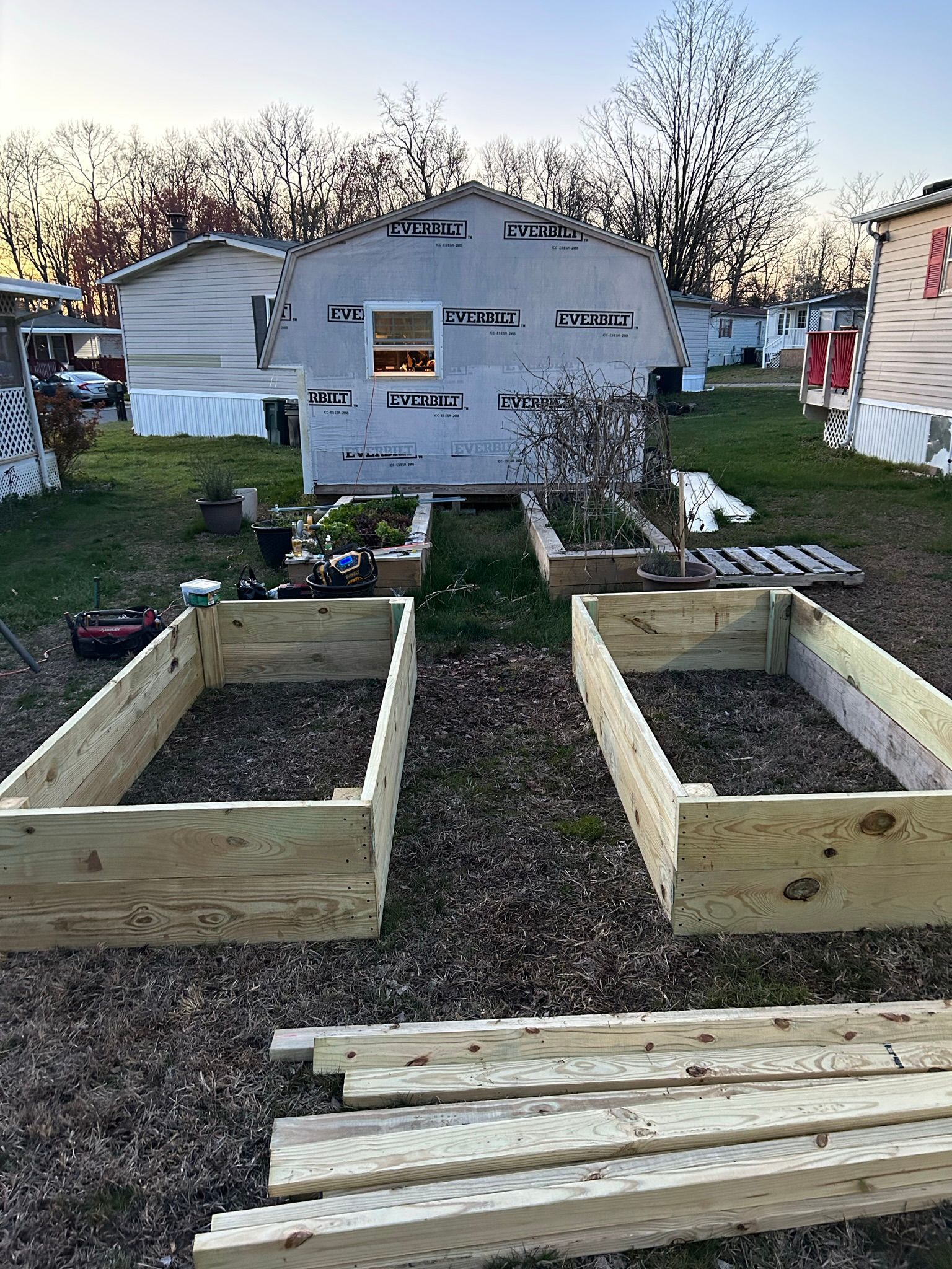 A bunch of wooden boxes are sitting in a yard in front of a house.