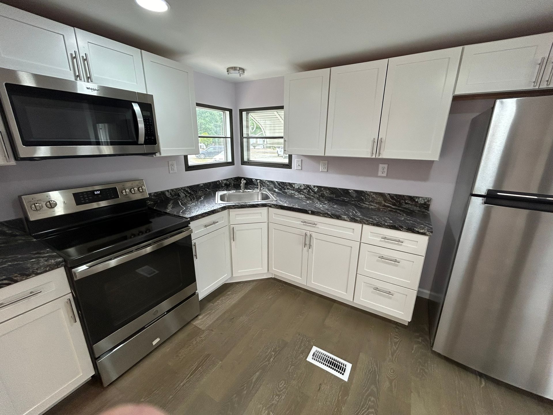 A kitchen with stainless steel appliances and white cabinets