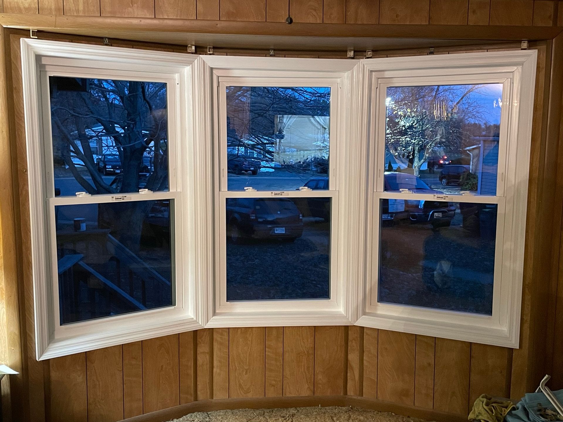 A living room with a large bay window and three windows.