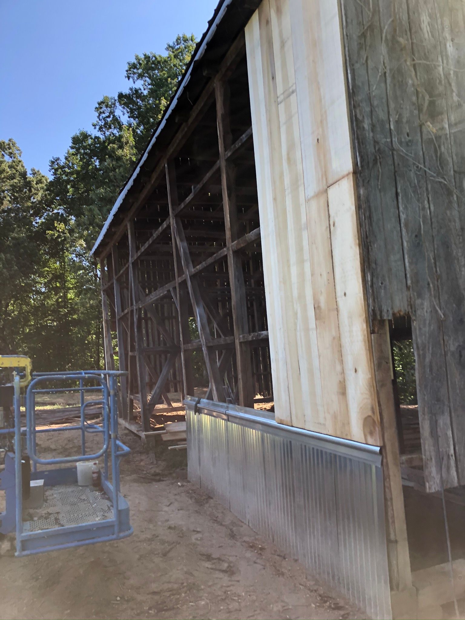 A large wooden building with a metal wall is being built.