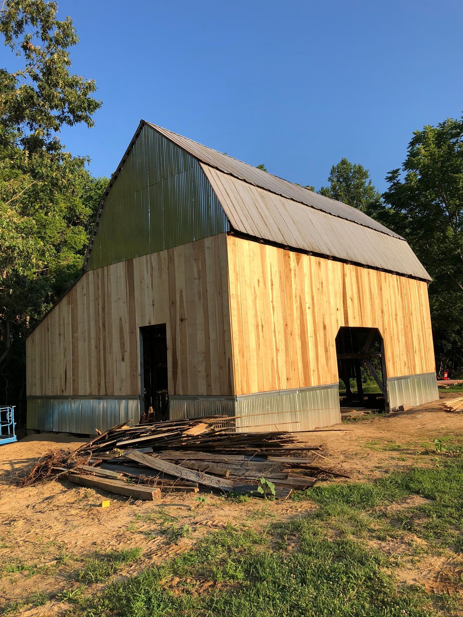 A barn is being built with wooden siding and a metal roof.