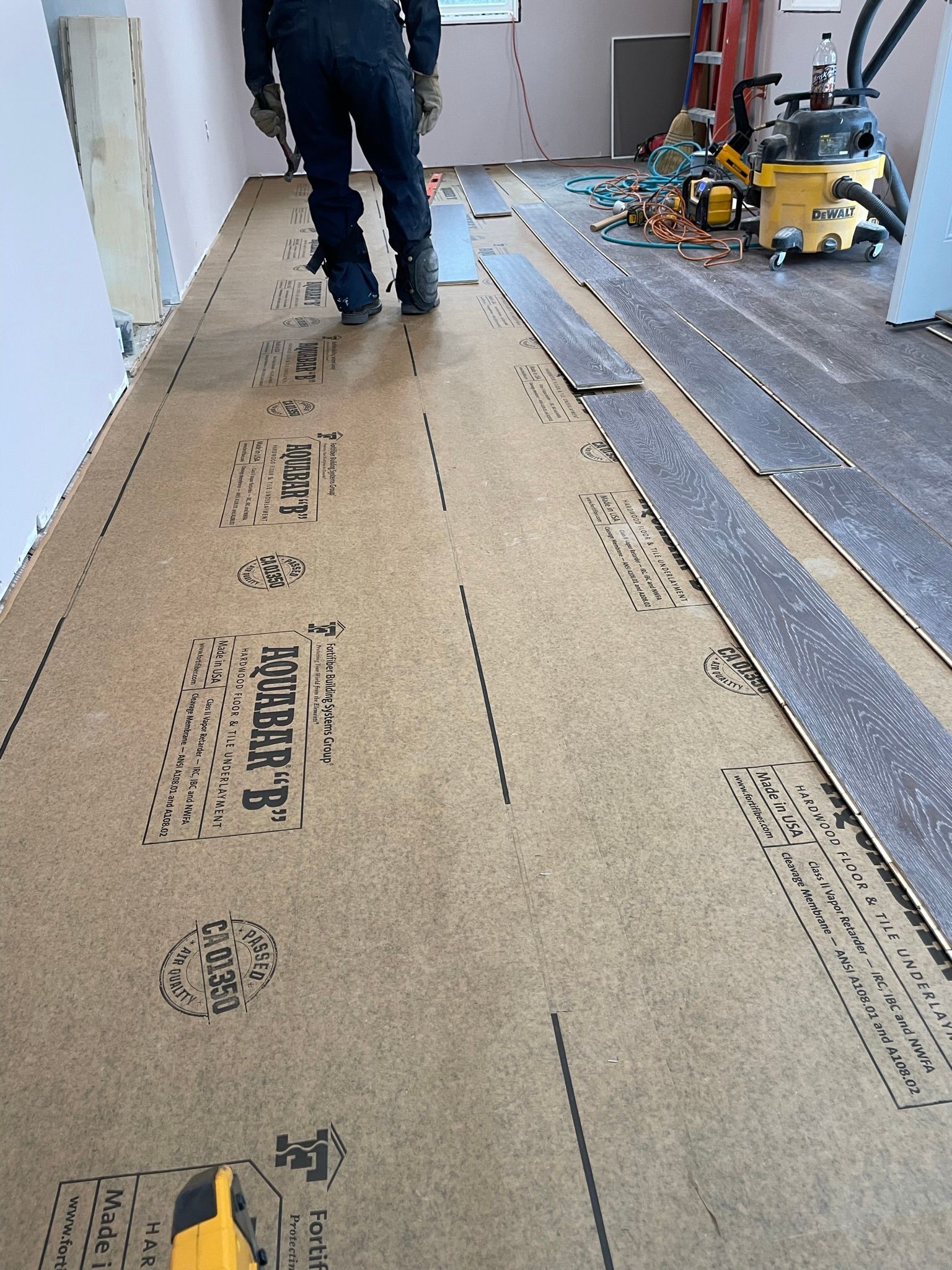 A man is standing on a wooden floor in a room.
