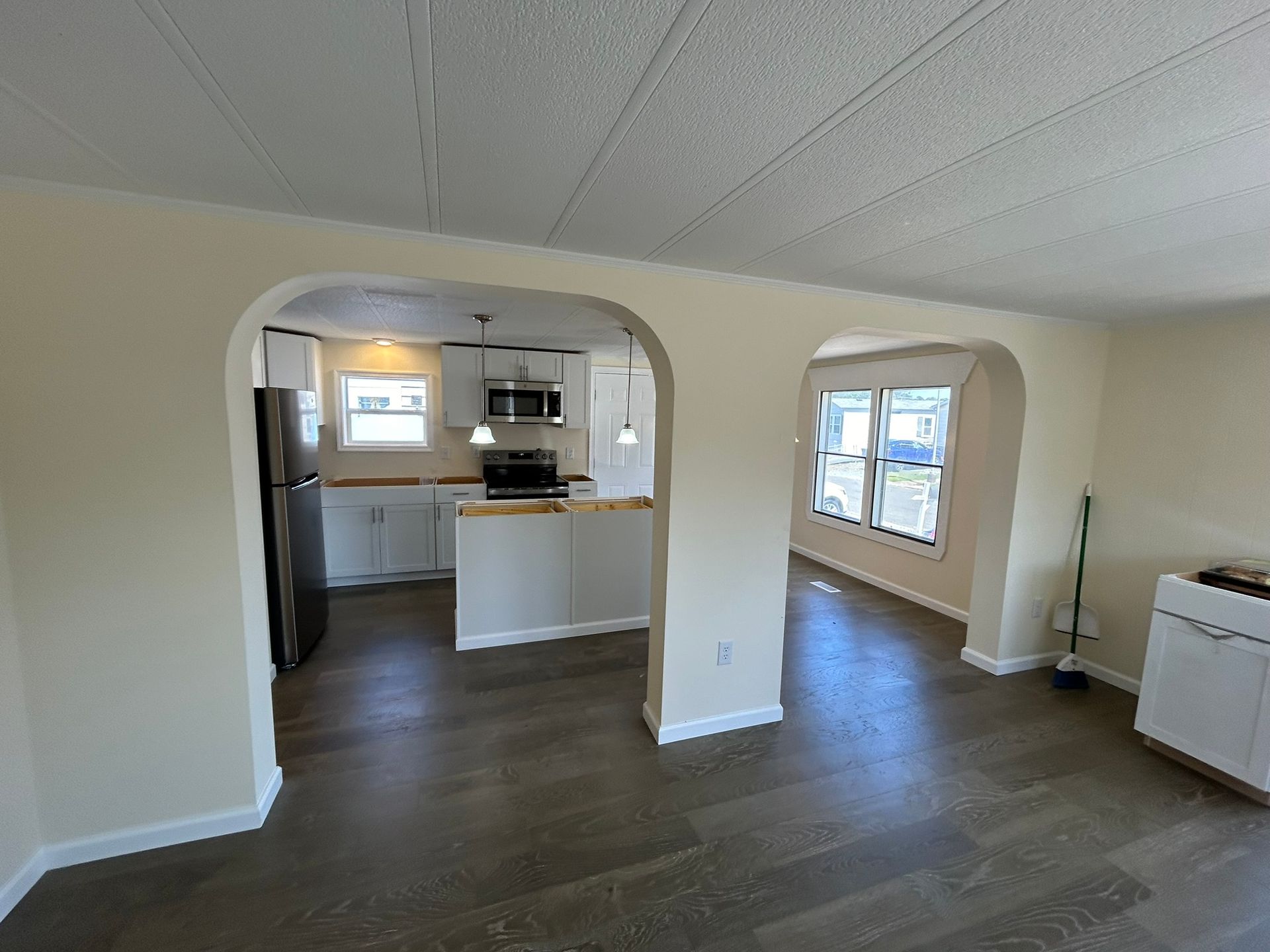 A kitchen and living room are connected by an archway.