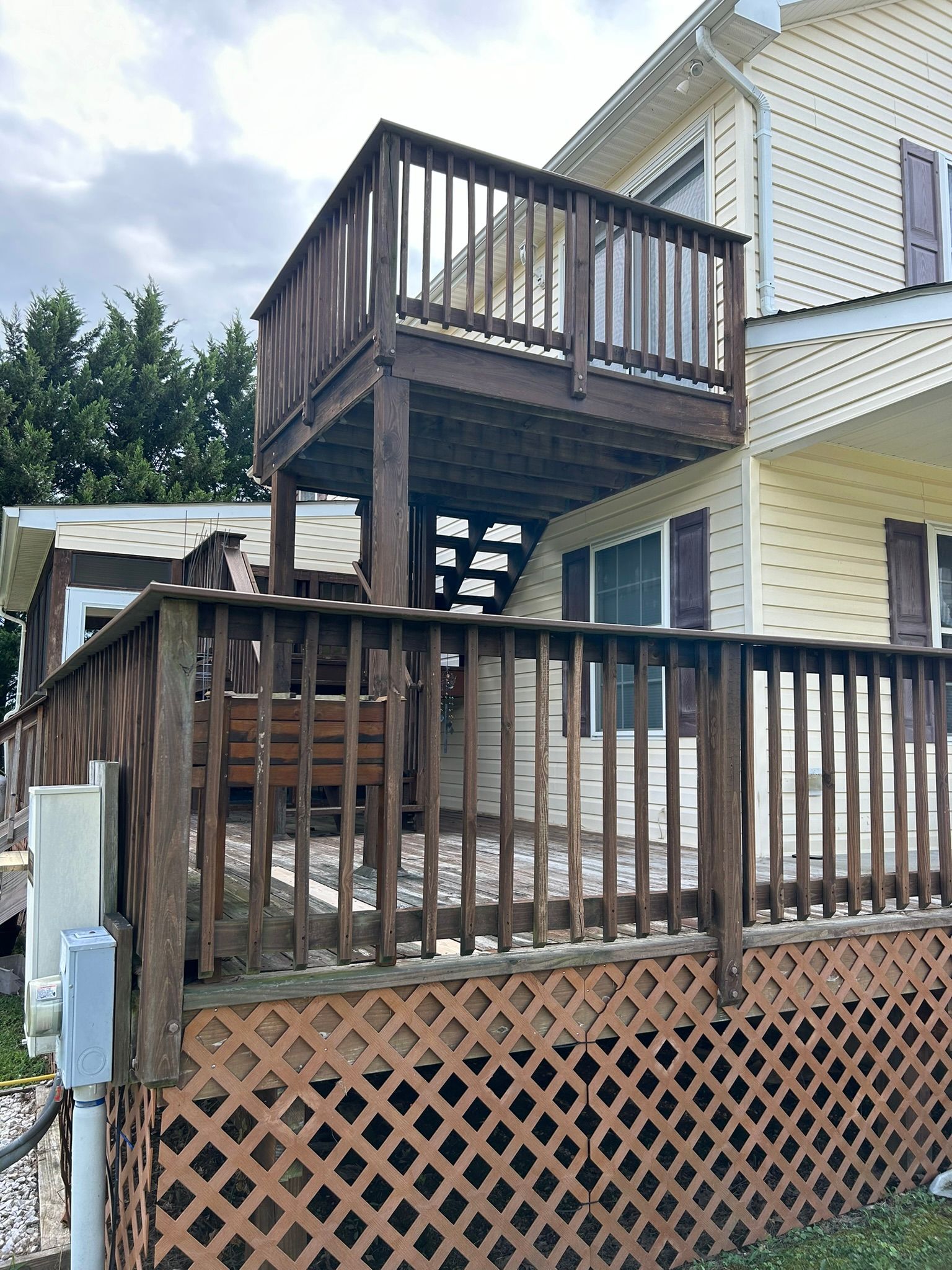 A house with a large wooden deck on the side of it.