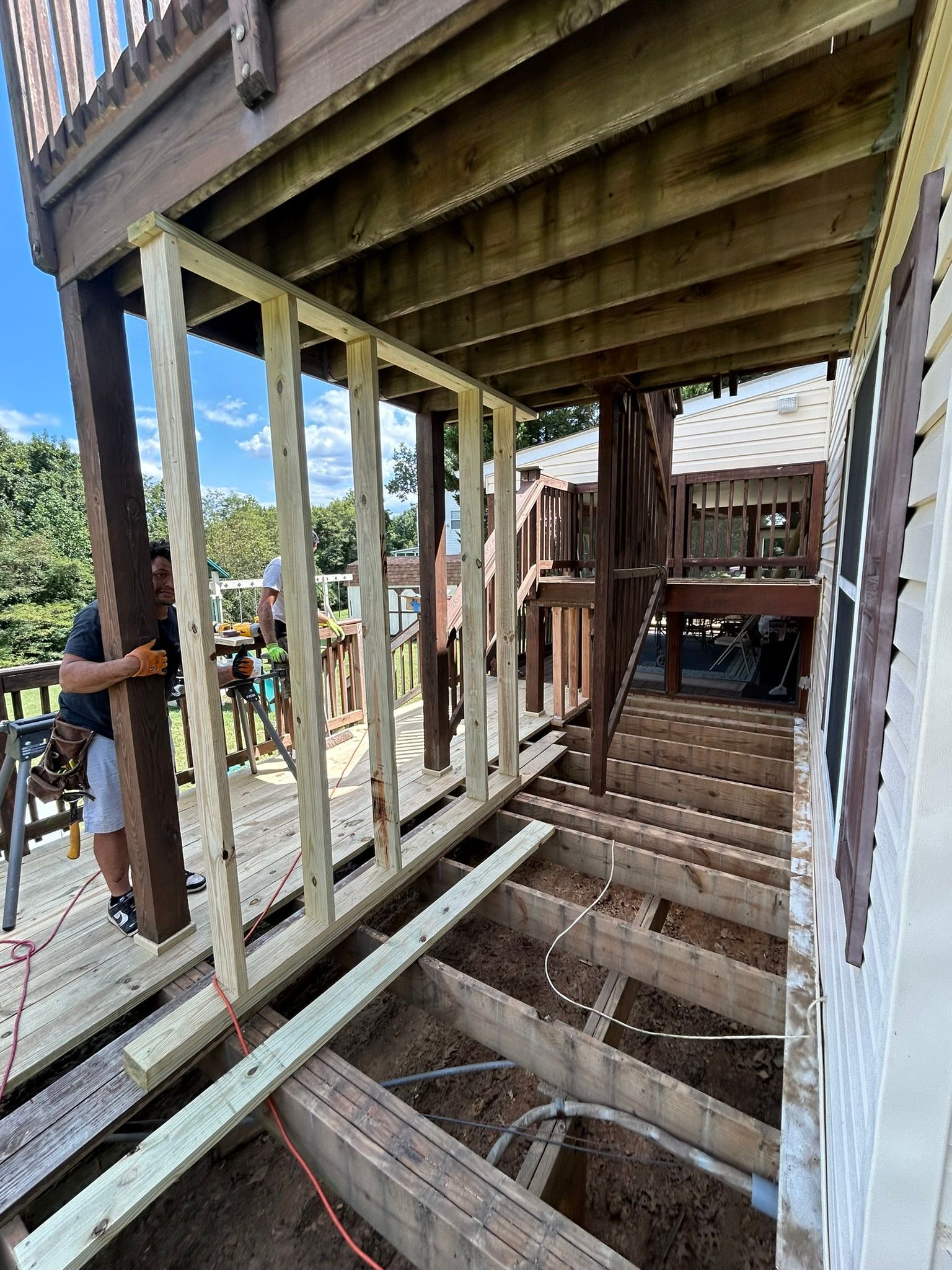 A man is standing on top of a wooden deck.