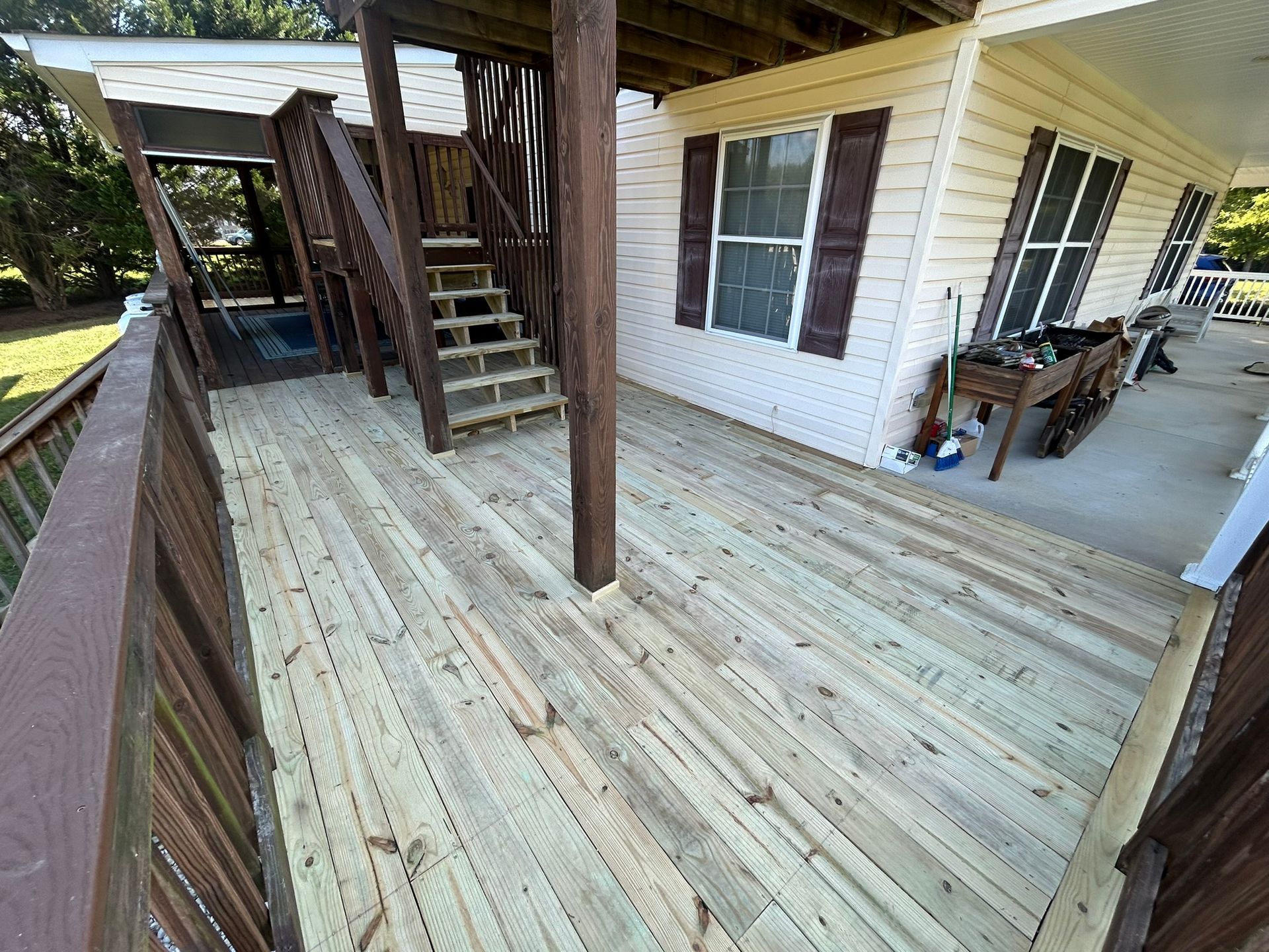 A wooden deck with stairs leading up to a house.