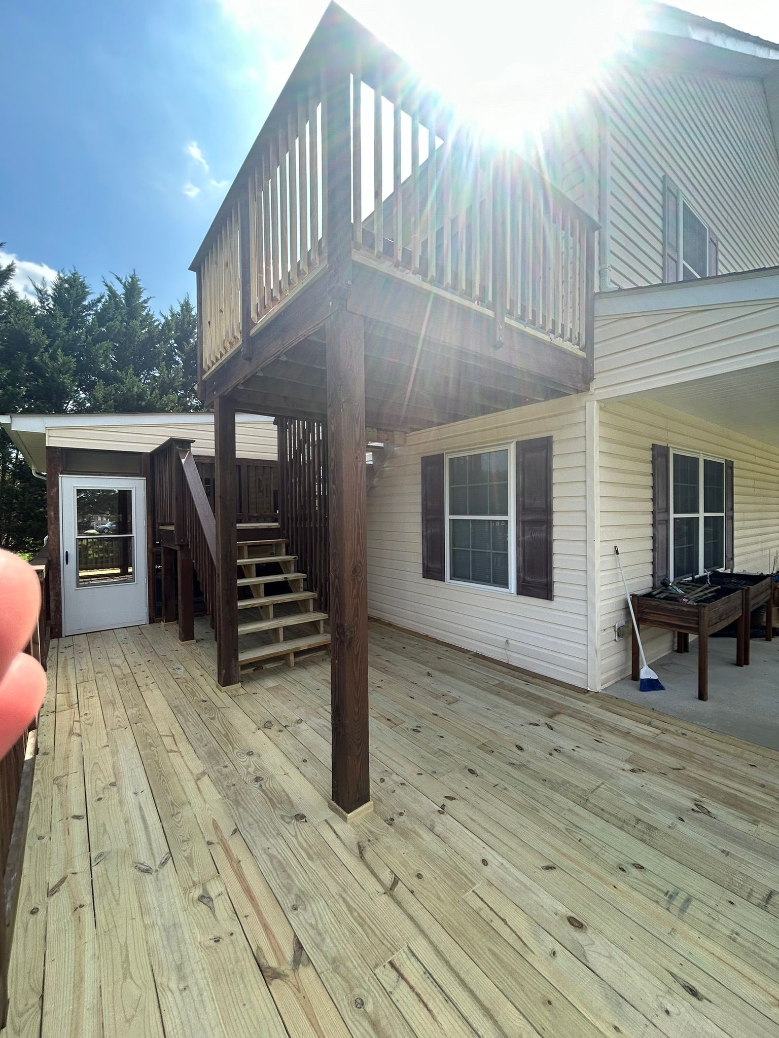 A white house with a wooden deck and stairs