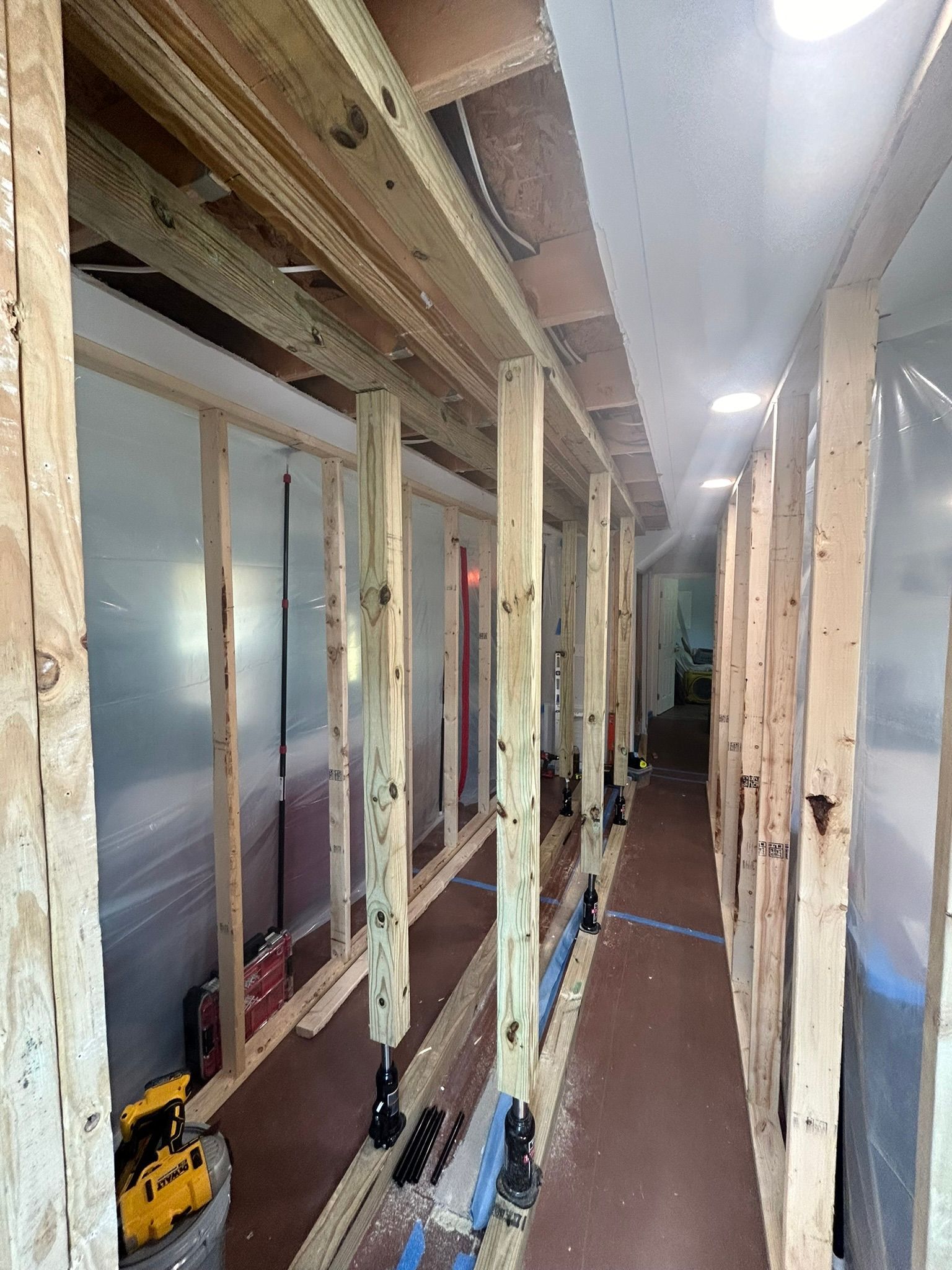 A long hallway with wooden beams and plastic covering.