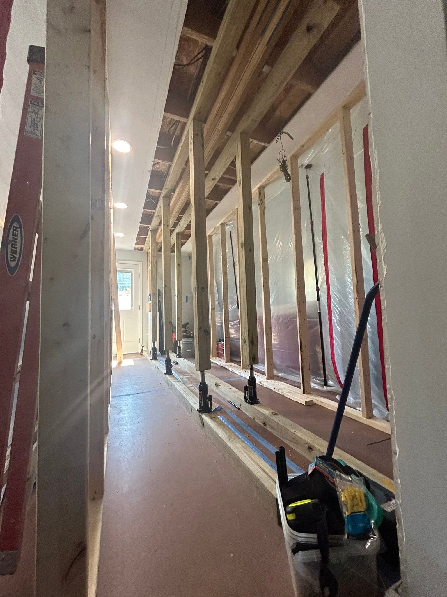 A long hallway with a vacuum cleaner in the middle of it.