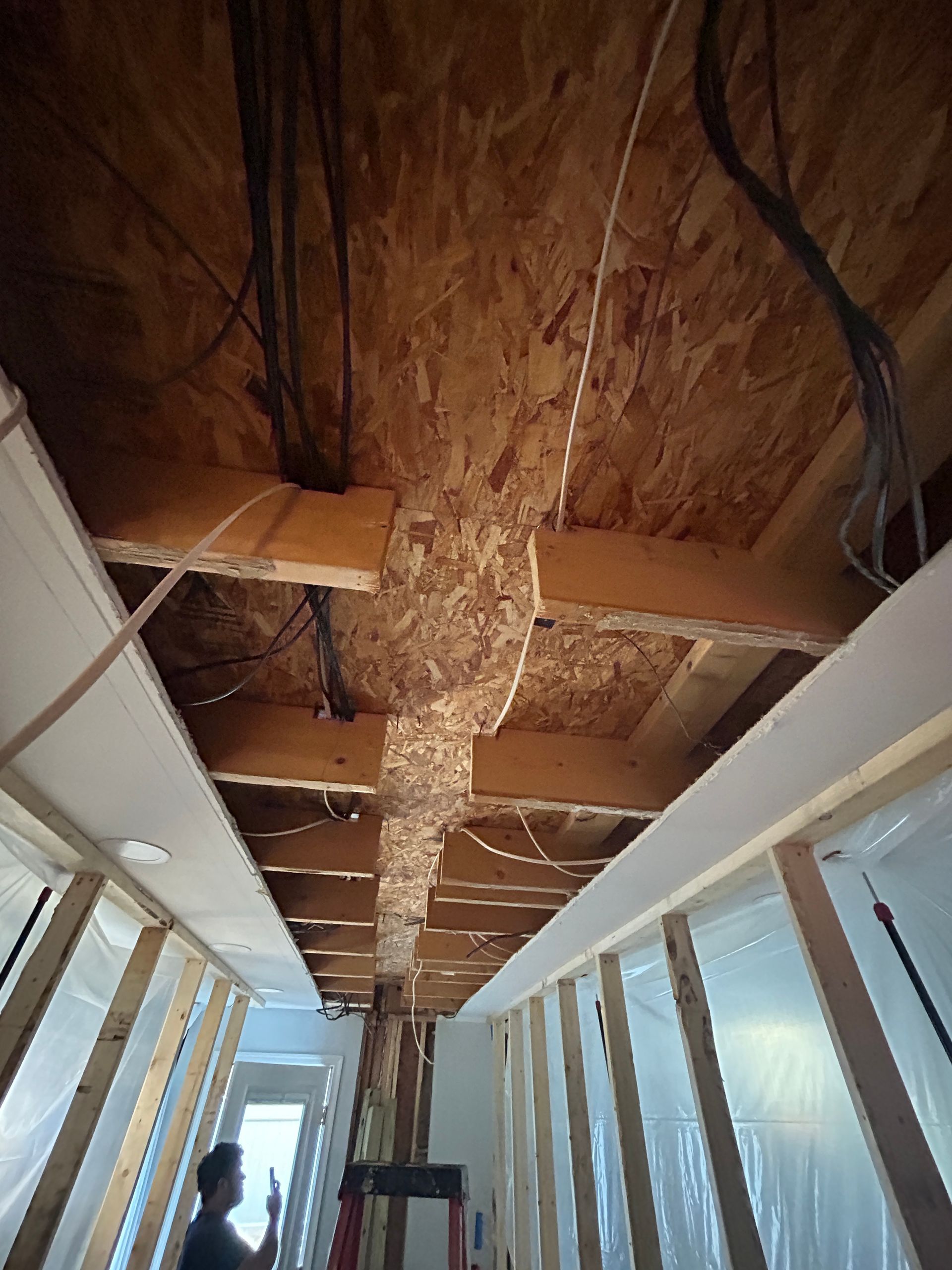 A man is working on the ceiling of a building.