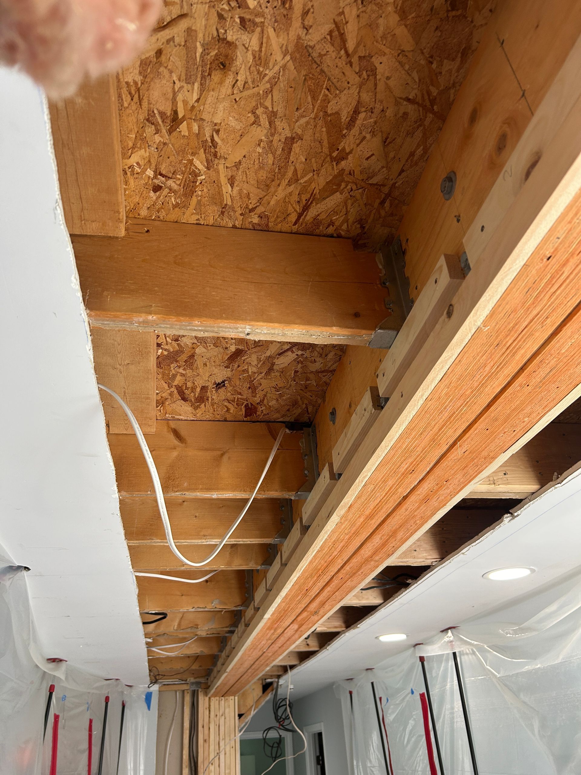 A person is looking up at the ceiling of a building under construction.