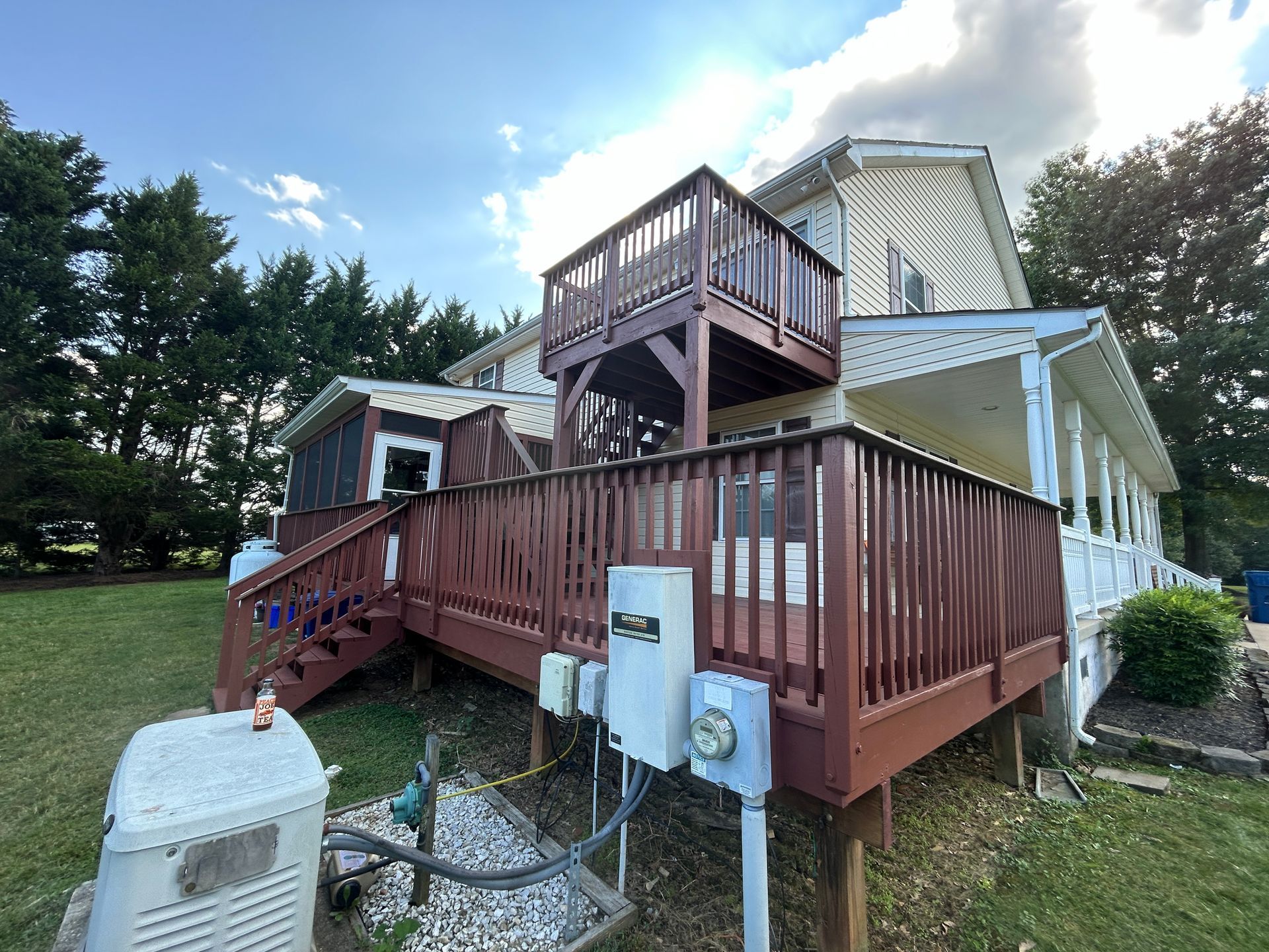 The back of a house with a large deck and stairs.