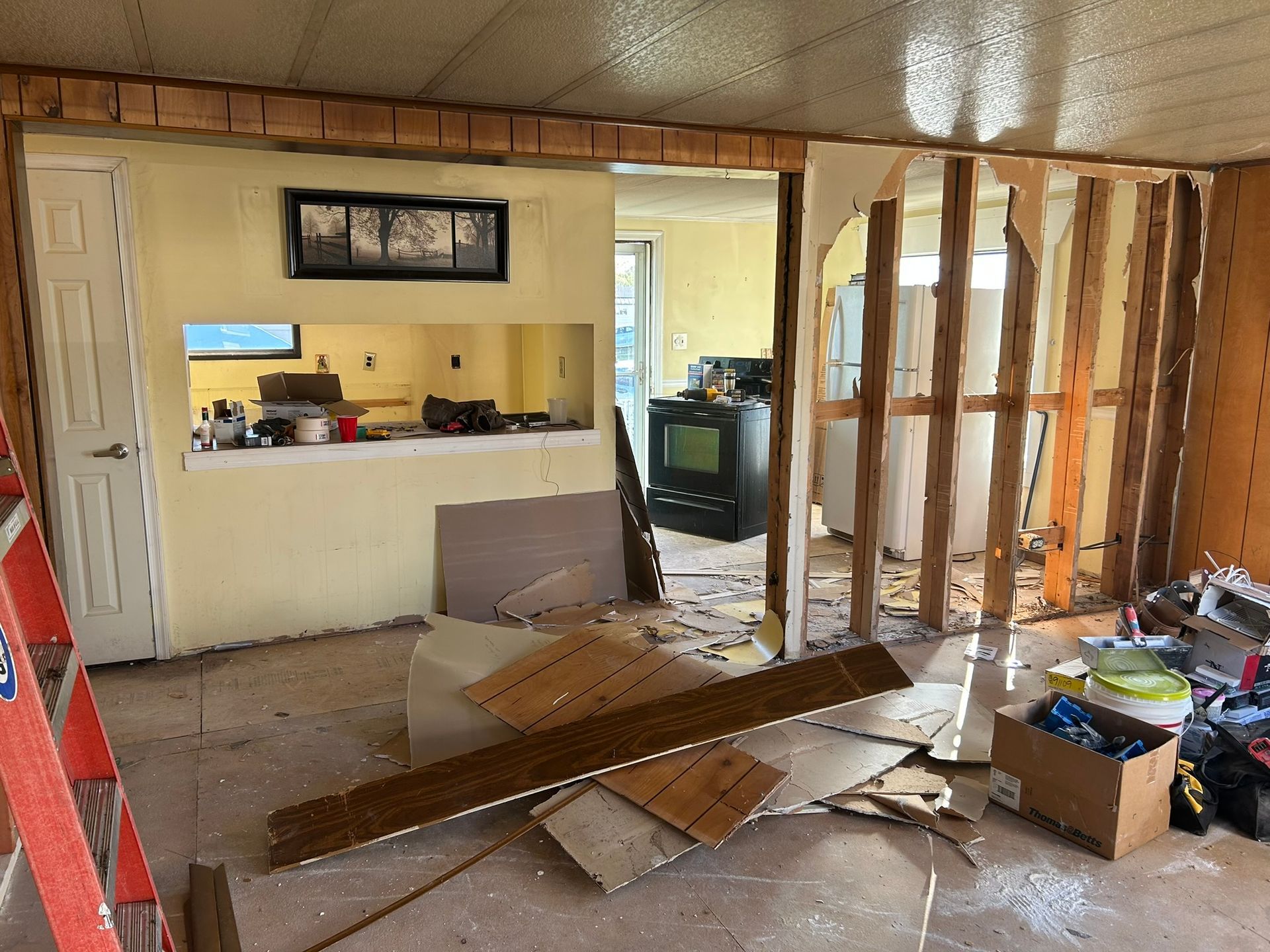 A room that is being remodeled with a ladder in the foreground.