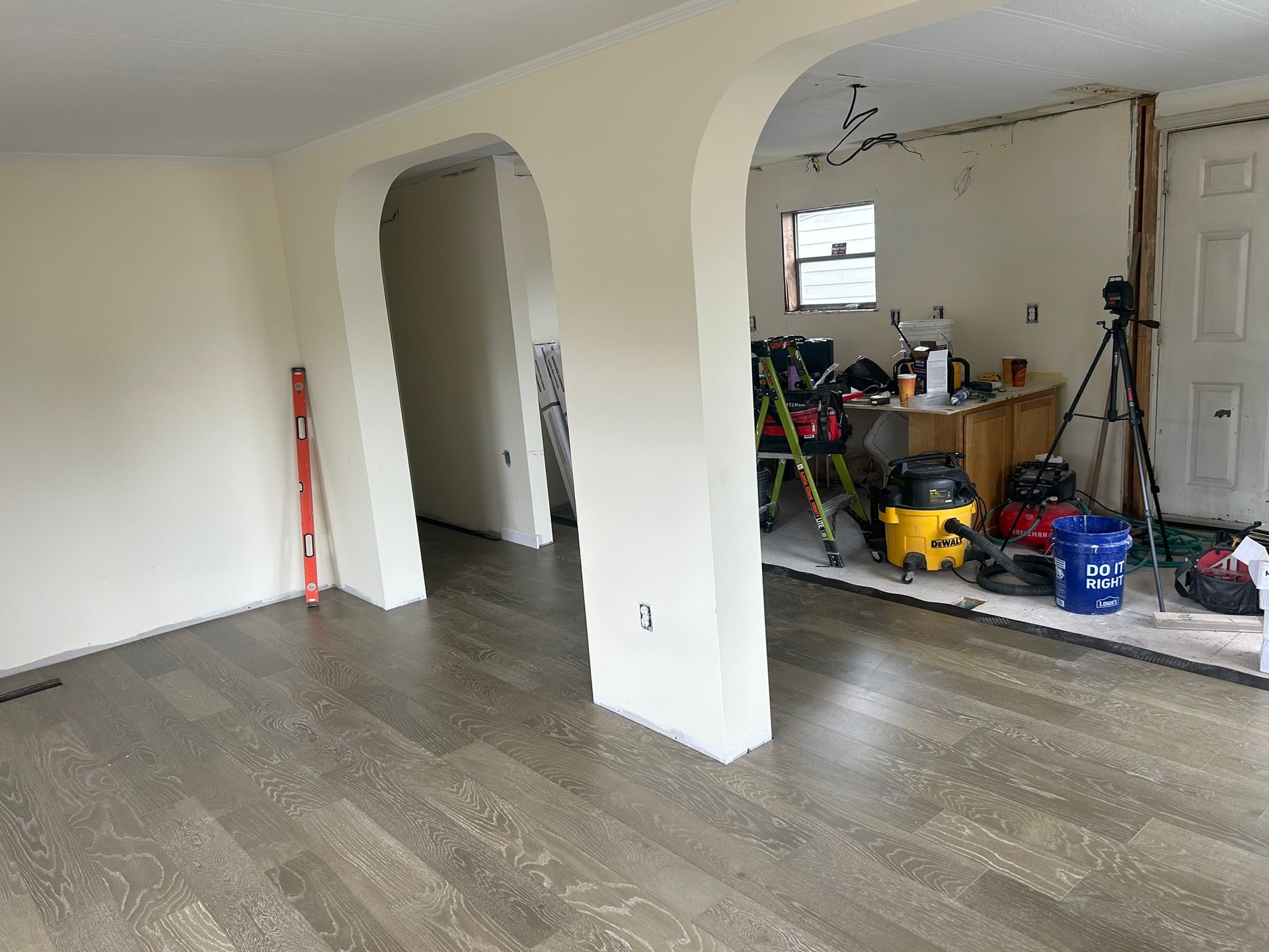 A room with hardwood floors and white walls is being remodeled.