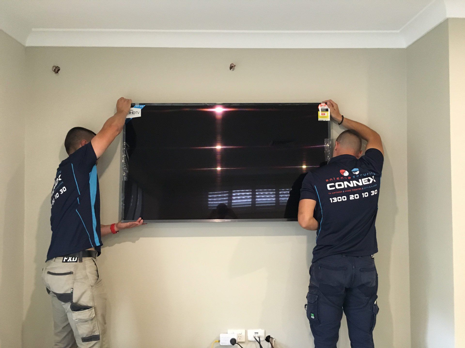 Two Man Installing a TV — Greater Sydney, Nsw — Connex Antenna & Security