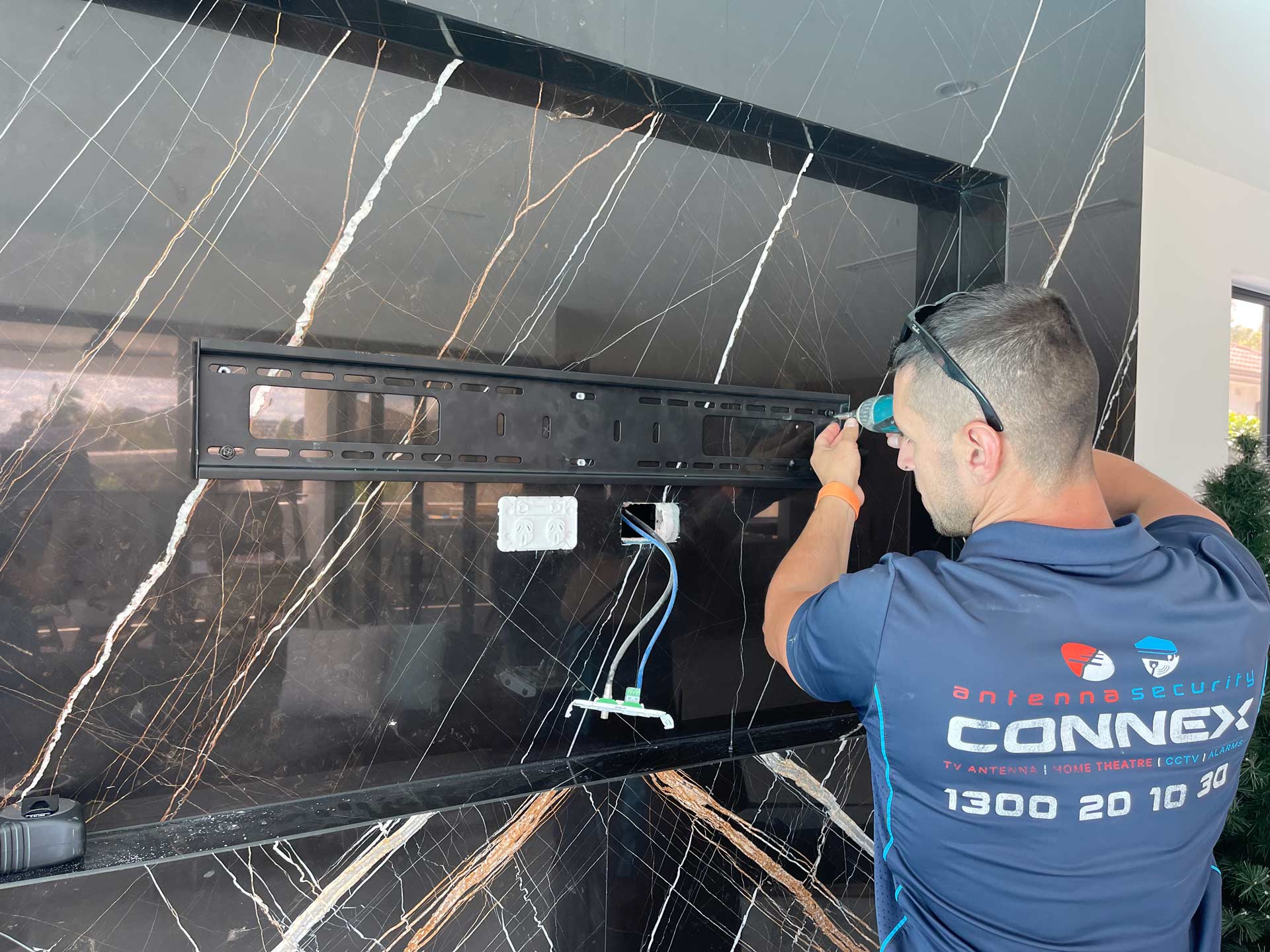 A Man Installing a Wall Mount for TV — Greater Sydney, Nsw — Connex Antenna & Security