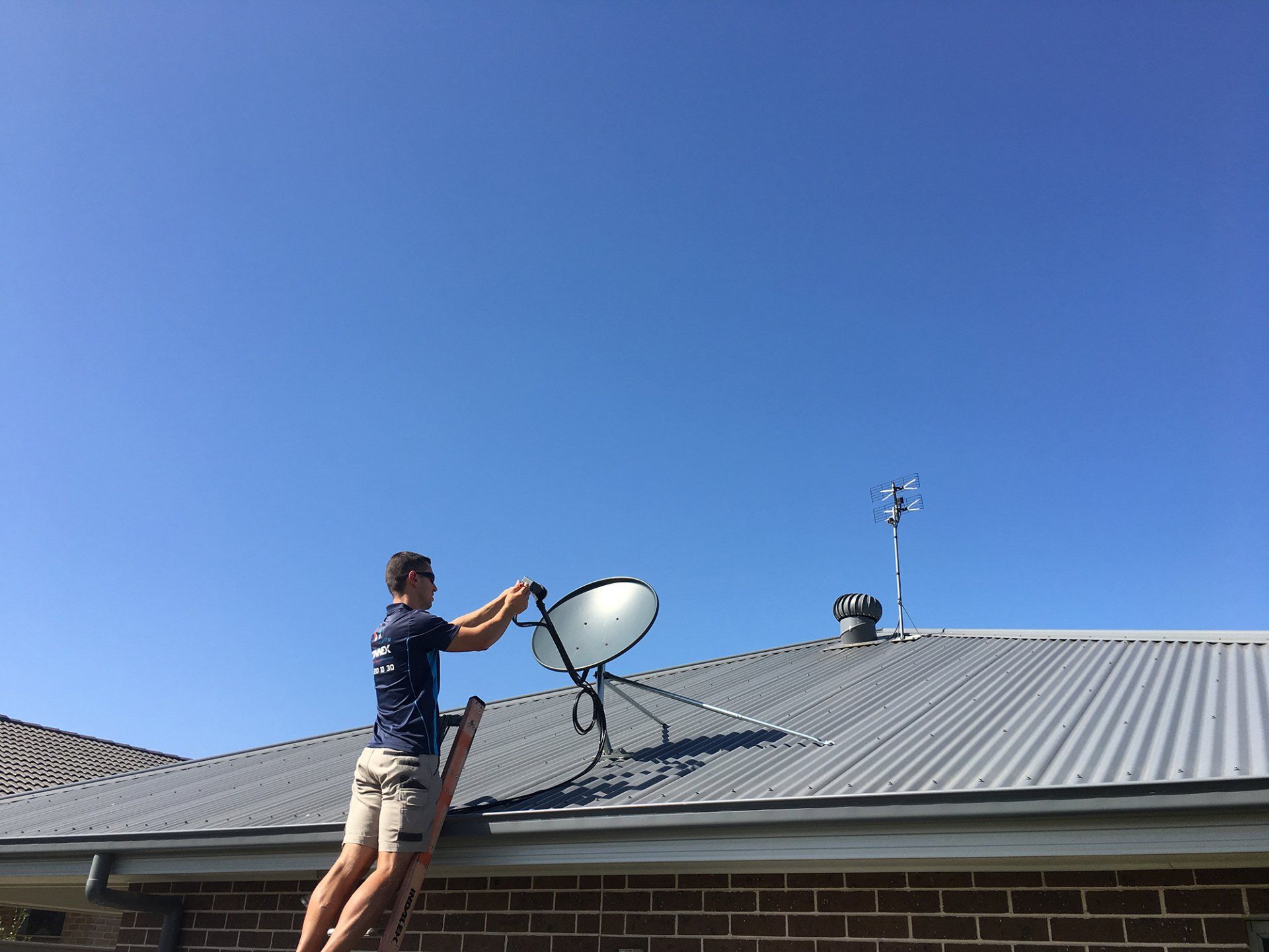 Man Installing TV Antenna on the Roof — Greater Sydney, NSW — Connex Antenna & Security