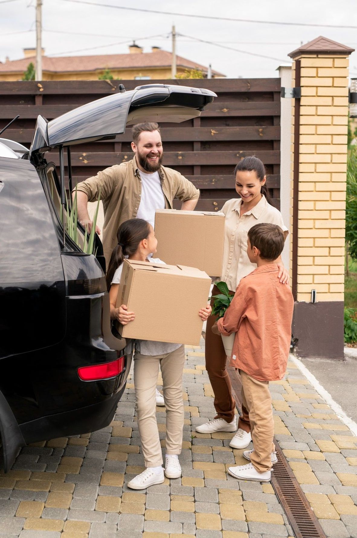 A family is loading boxes into the back of a car.