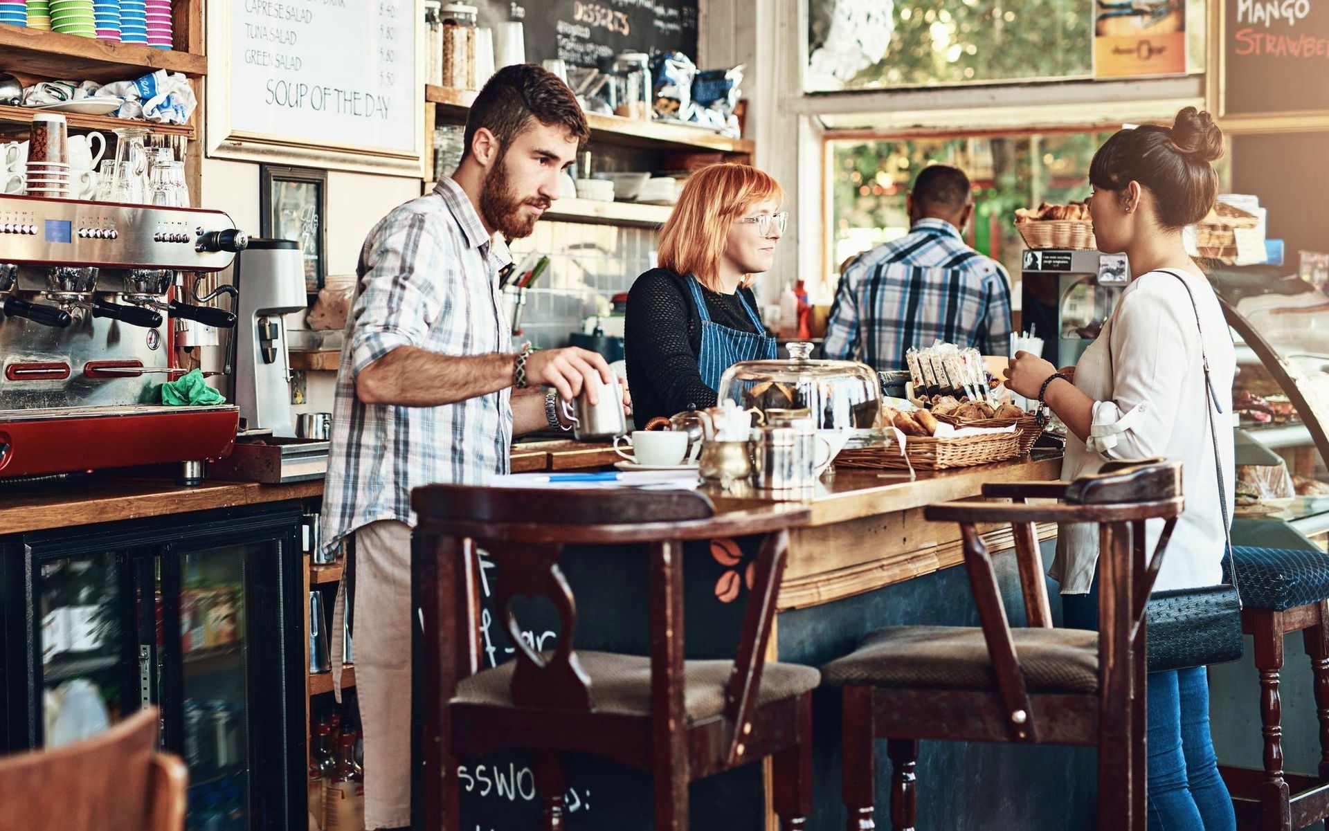 A group of people are sitting at tables in a cafe.