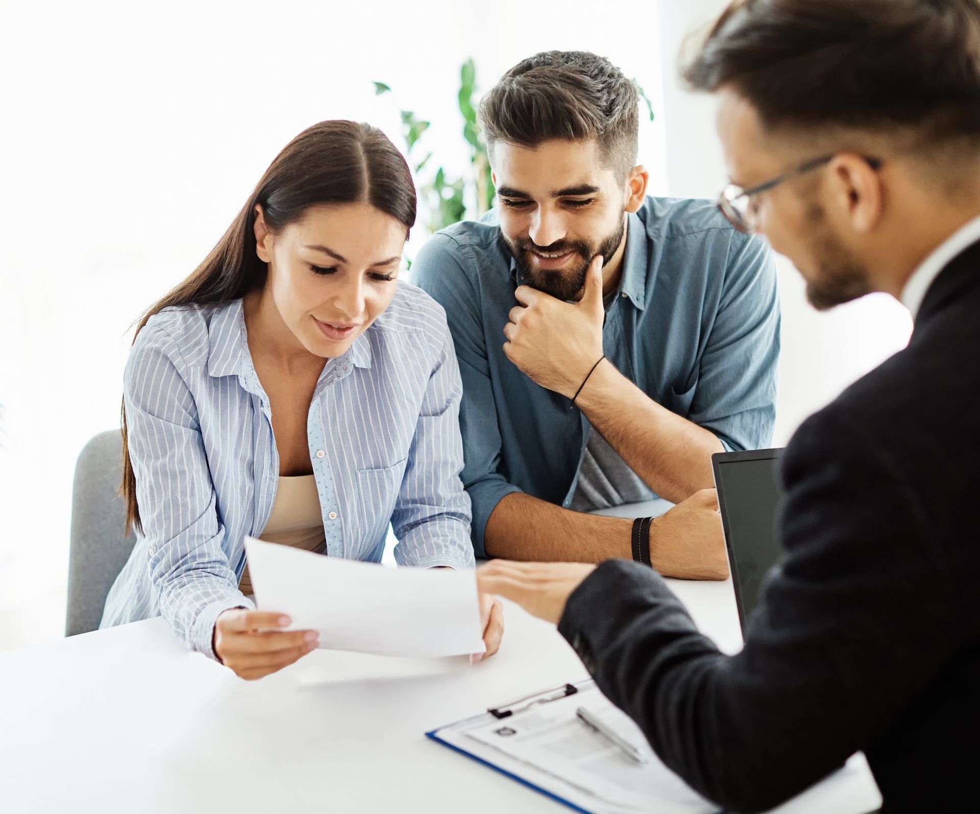 A man and a woman are sitting at a table looking at a piece of paper.