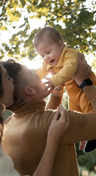 A man and woman are holding a baby in their arms.