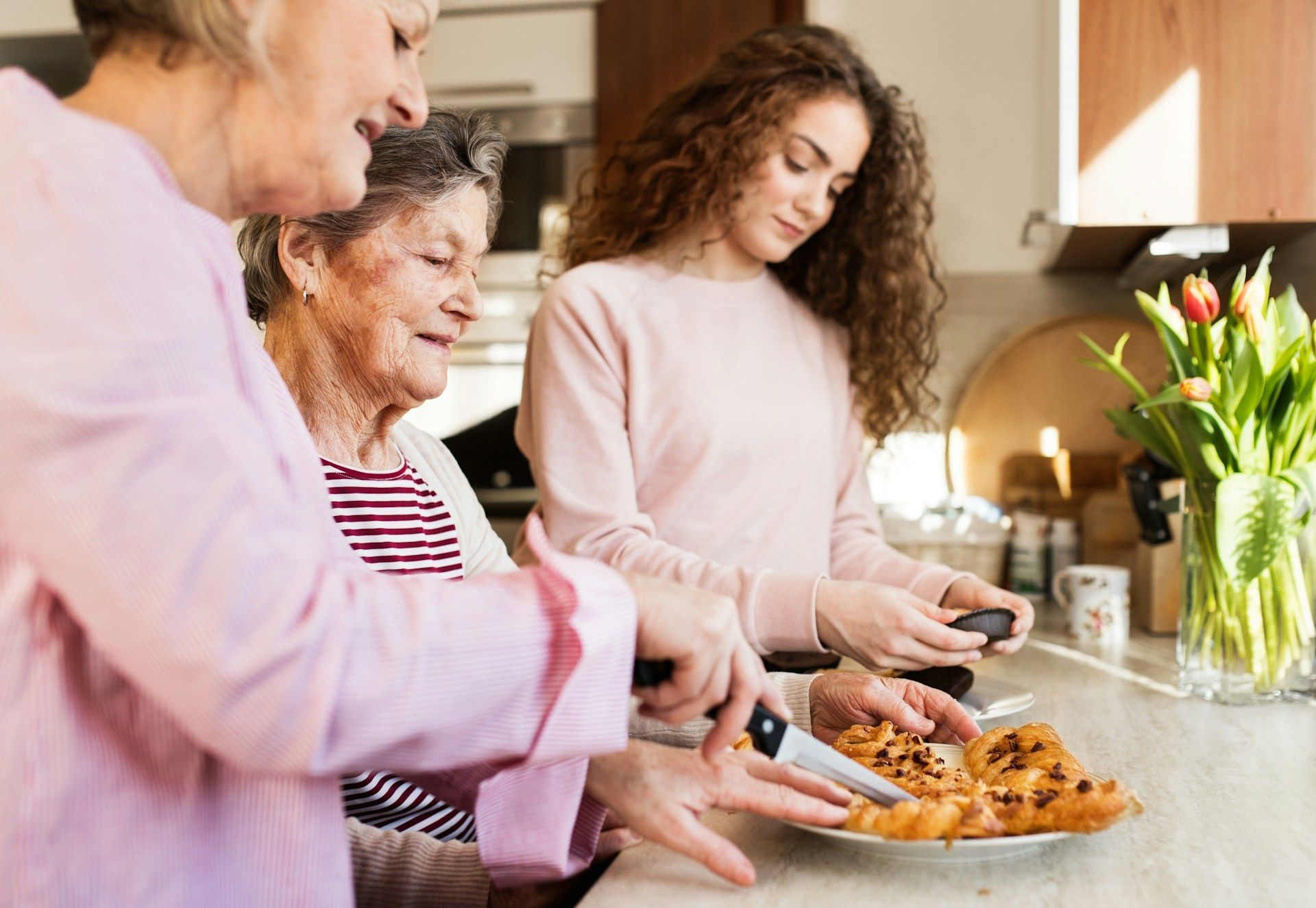 A woman is taking a picture of a plate of food with a cell phone.
