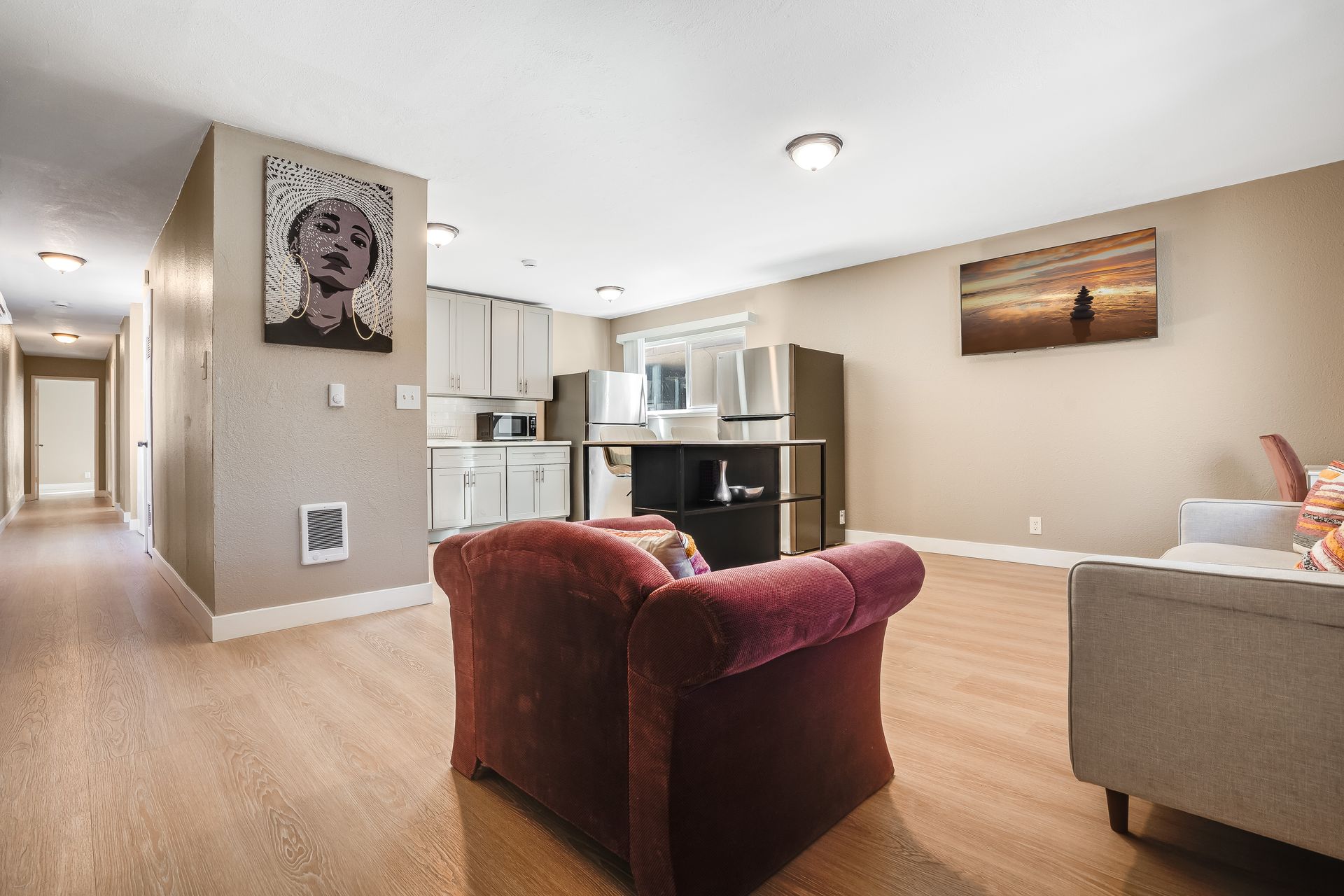 A living room with a couch , chair , and painting on the wall.
