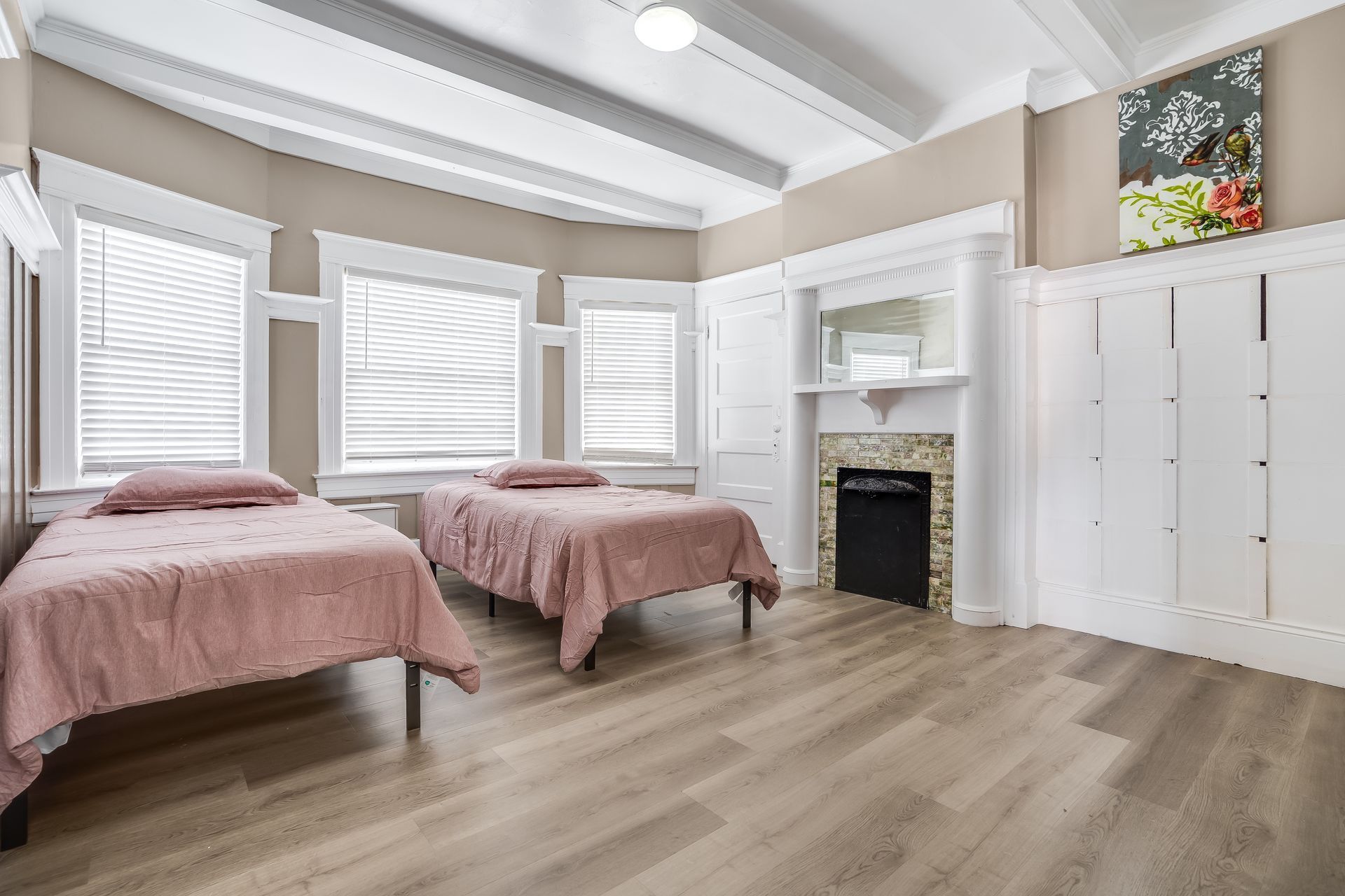A bedroom with two beds and a fireplace.