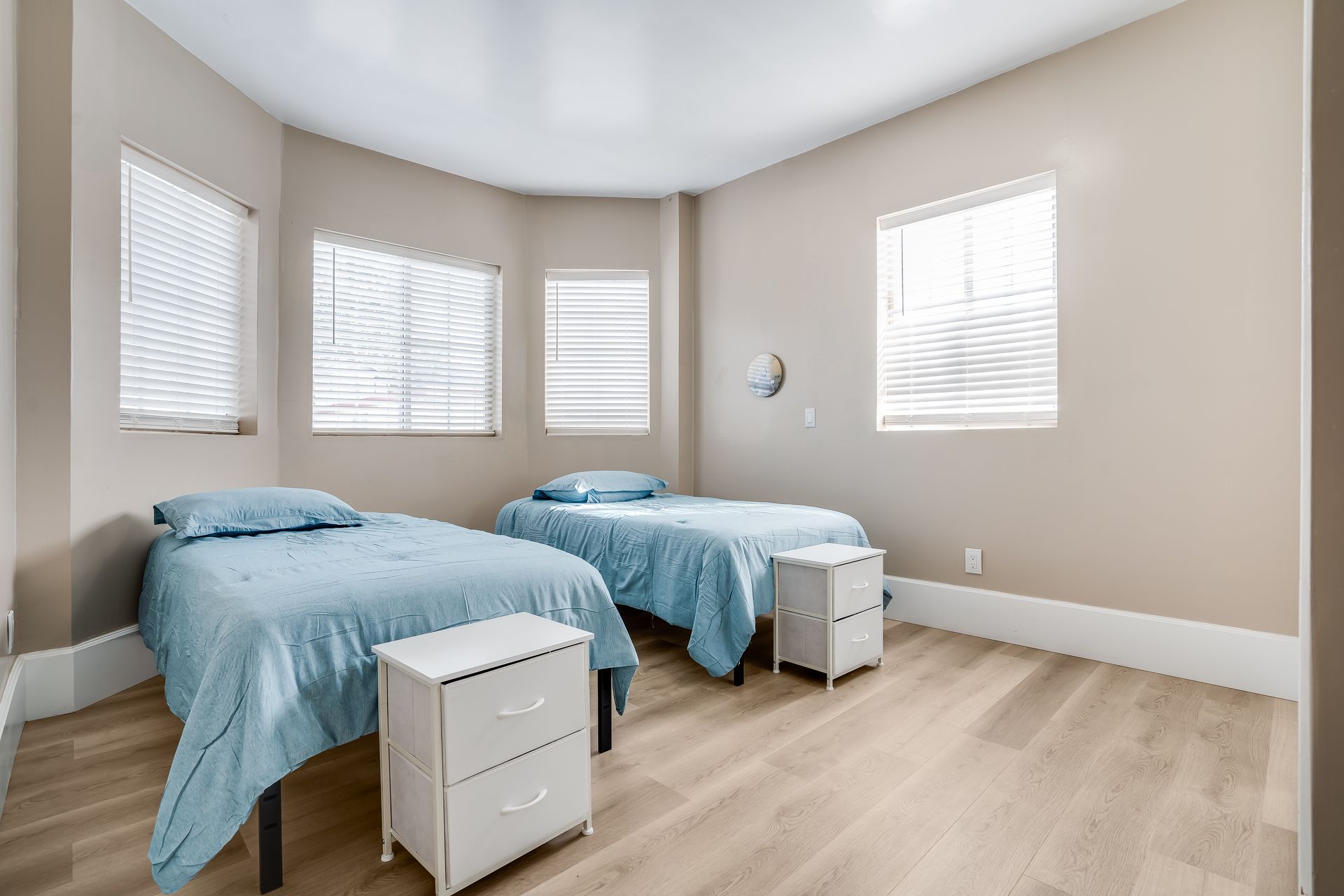 A bedroom with two beds and two nightstands.