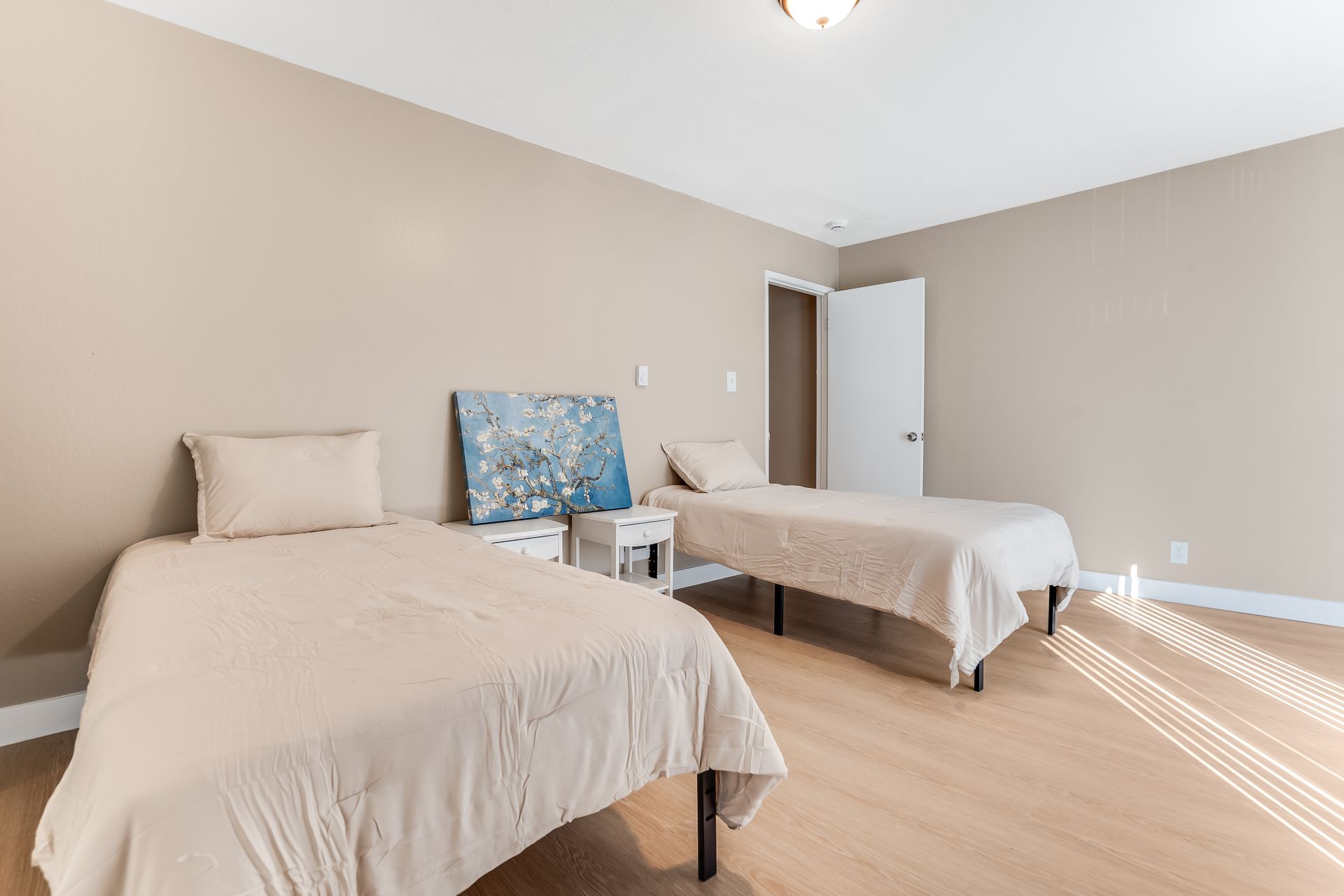 A bedroom with two twin beds and a nightstand.