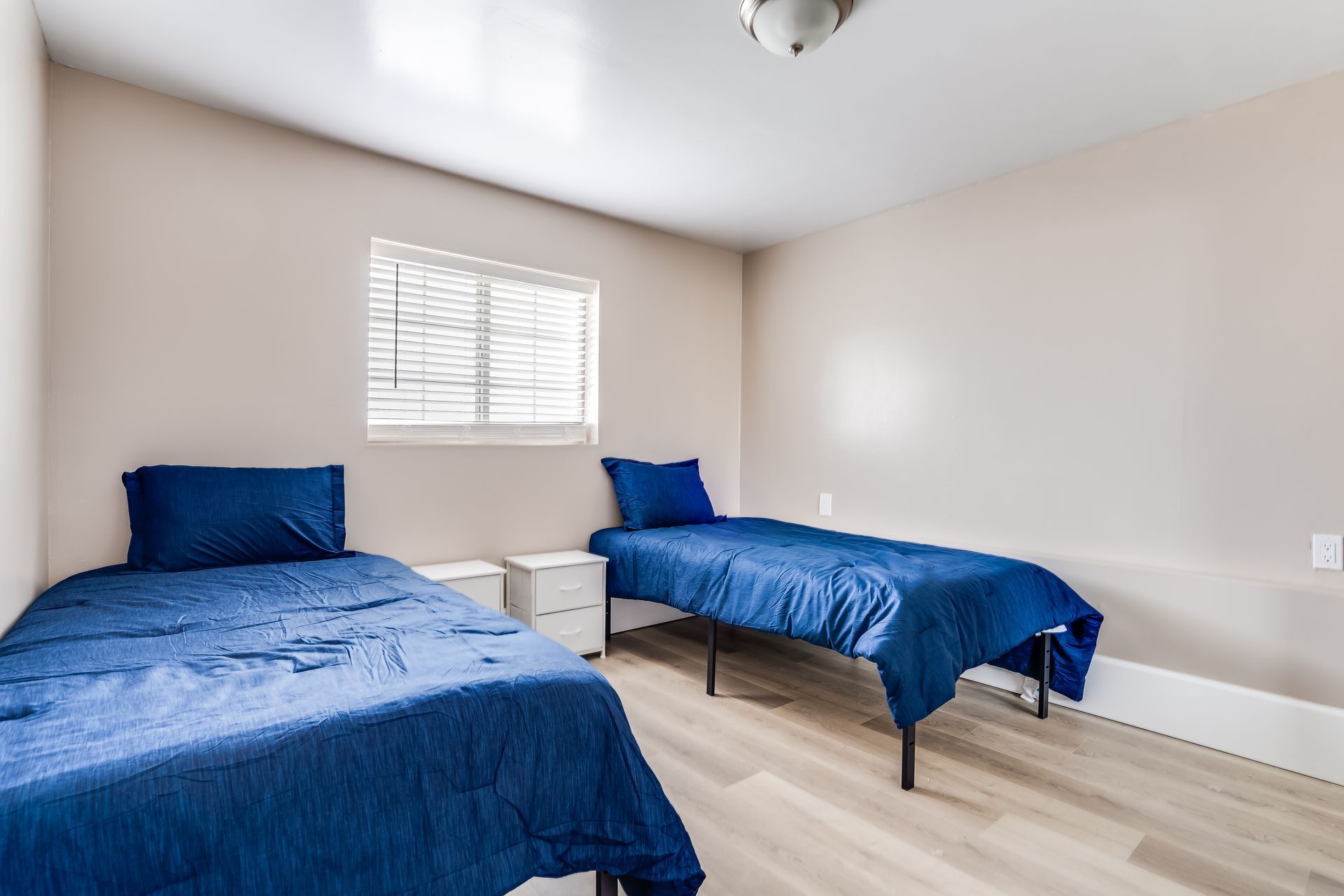 A bedroom with two beds and a window.