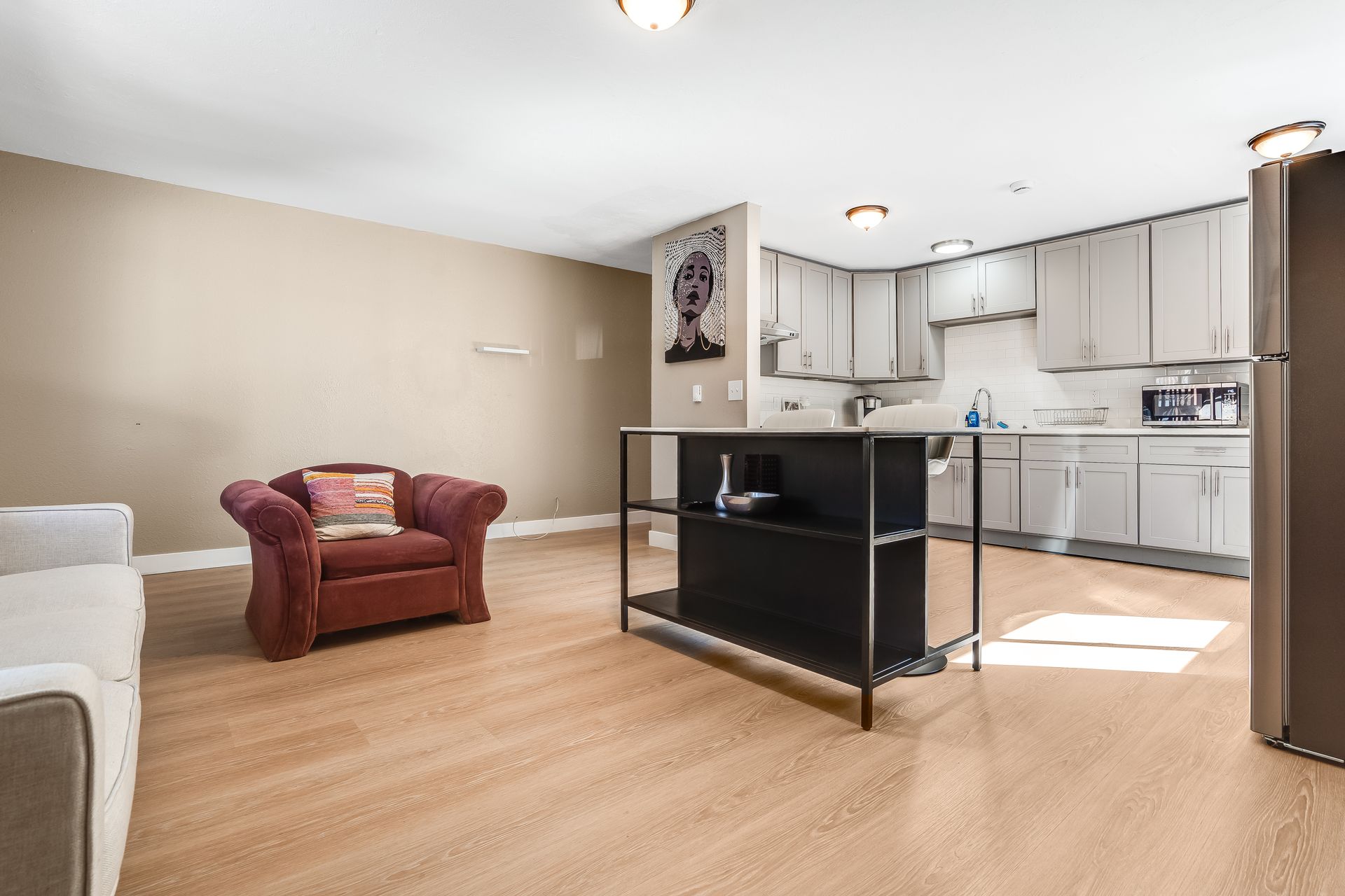A living room with a chair , couch , and kitchen.