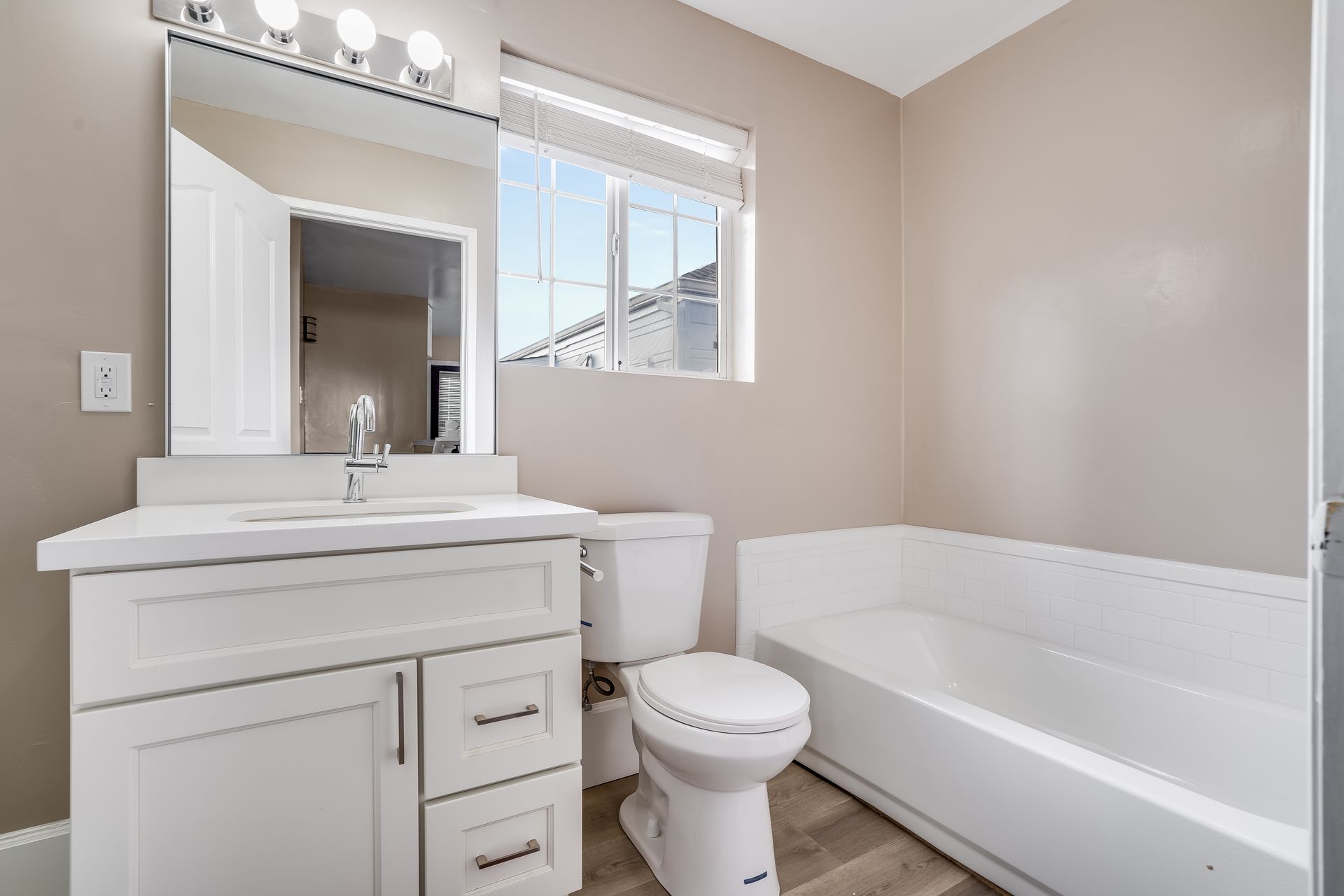 A bathroom with a toilet , sink , and bathtub.