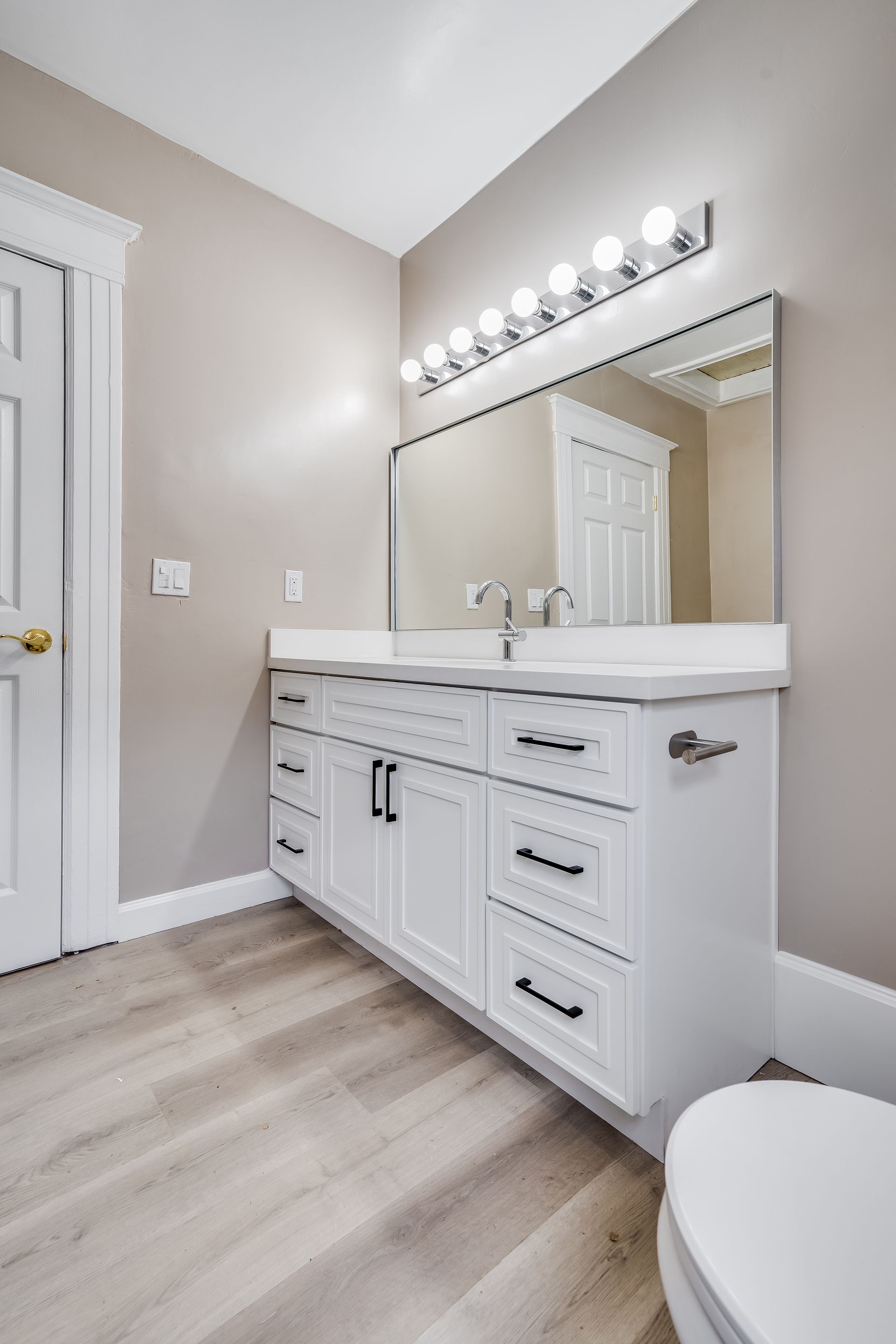 A bathroom with a sink , mirror and toilet.