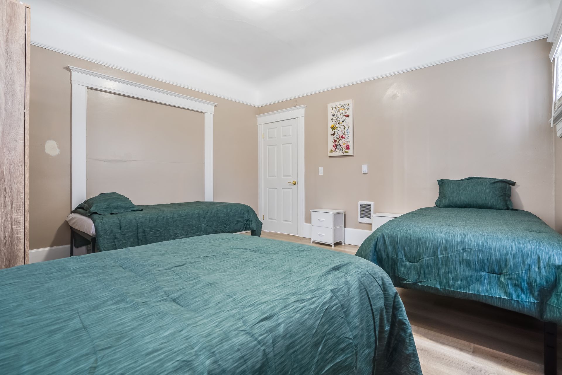 A bedroom with two beds and a closet.