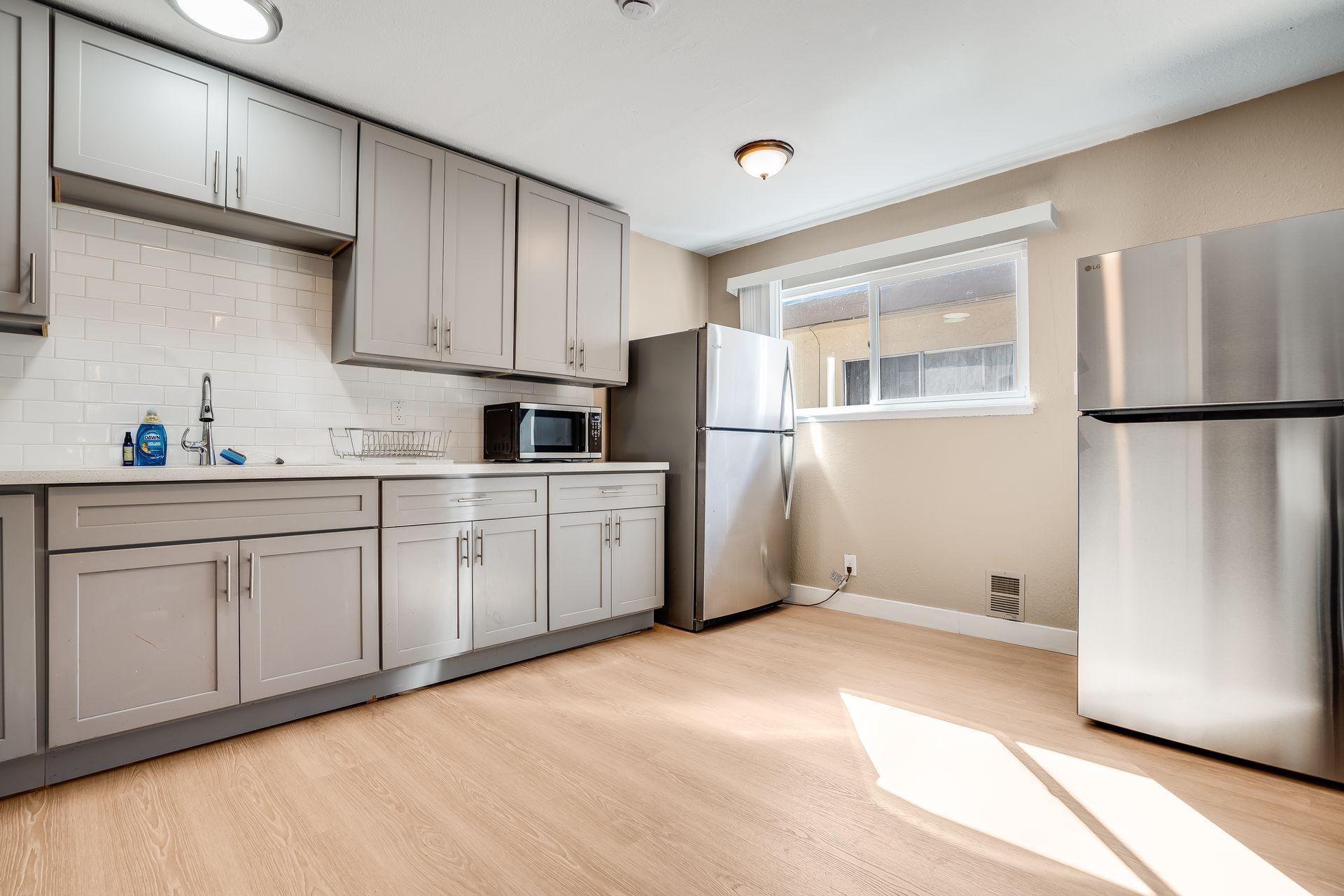 A kitchen with stainless steel appliances and white cabinets