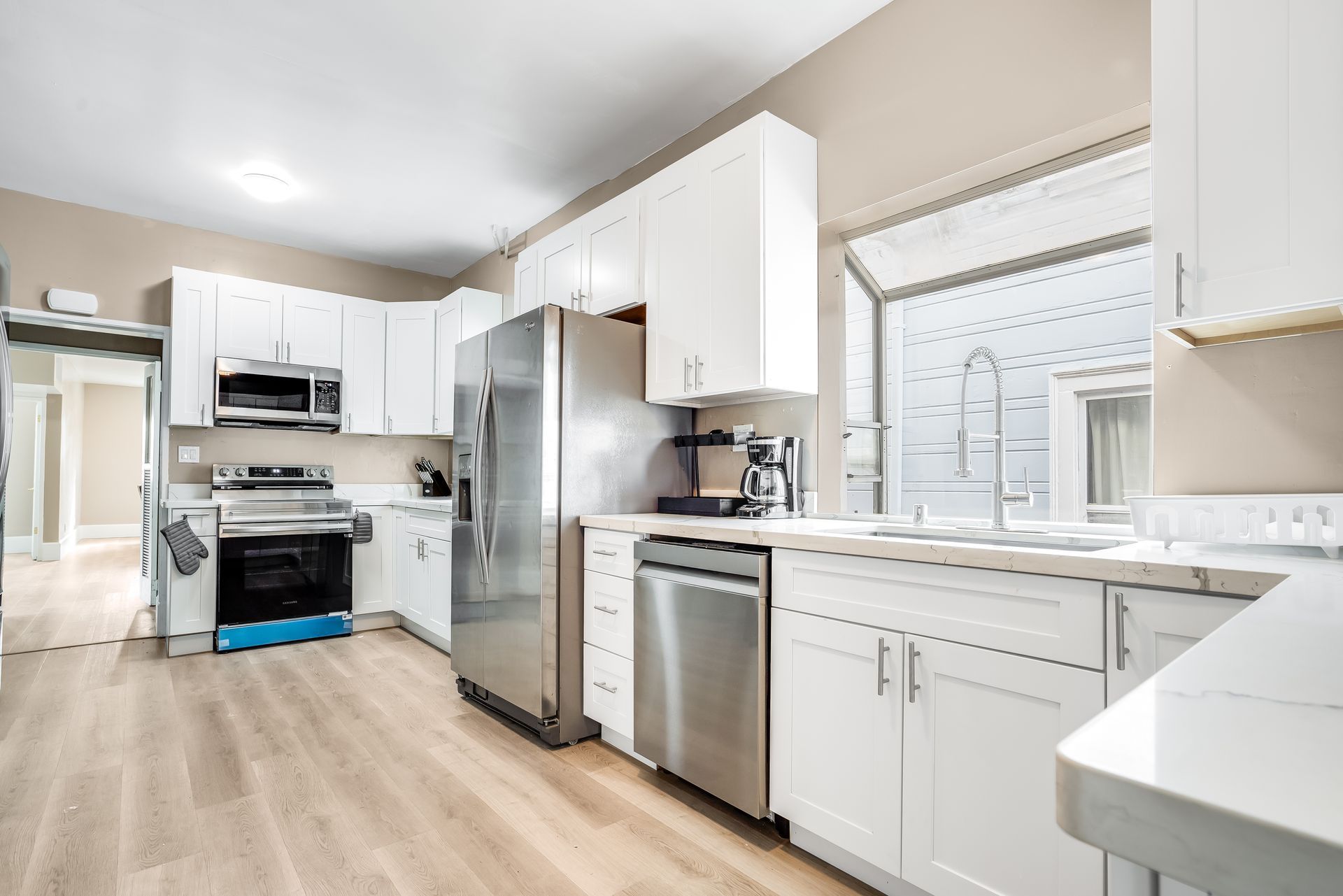 A kitchen with white cabinets and stainless steel appliances.