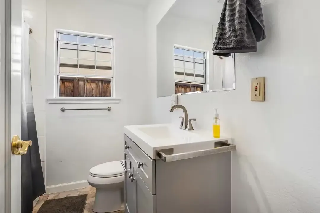 A bedroom with two beds and a sliding glass door.