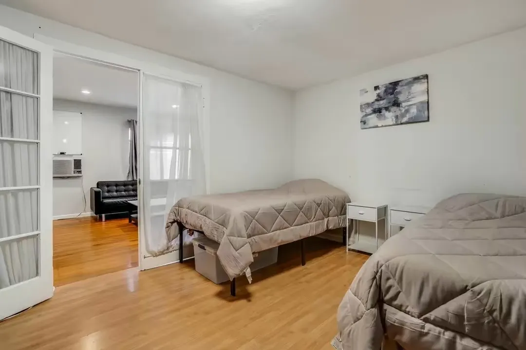 A bedroom with two beds and a window.