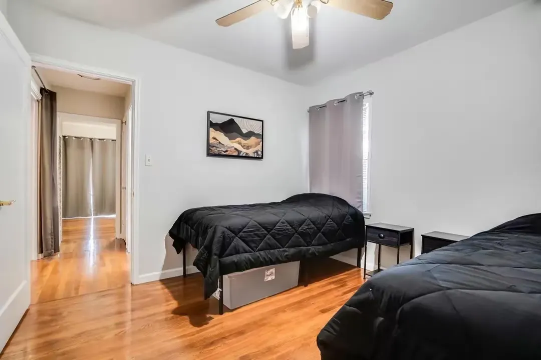 A bathroom with a toilet , sink , mirror and shower curtain.