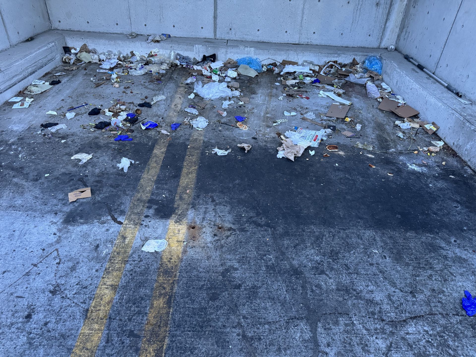 A dirty dumpster pad before it was cleaned by JET.