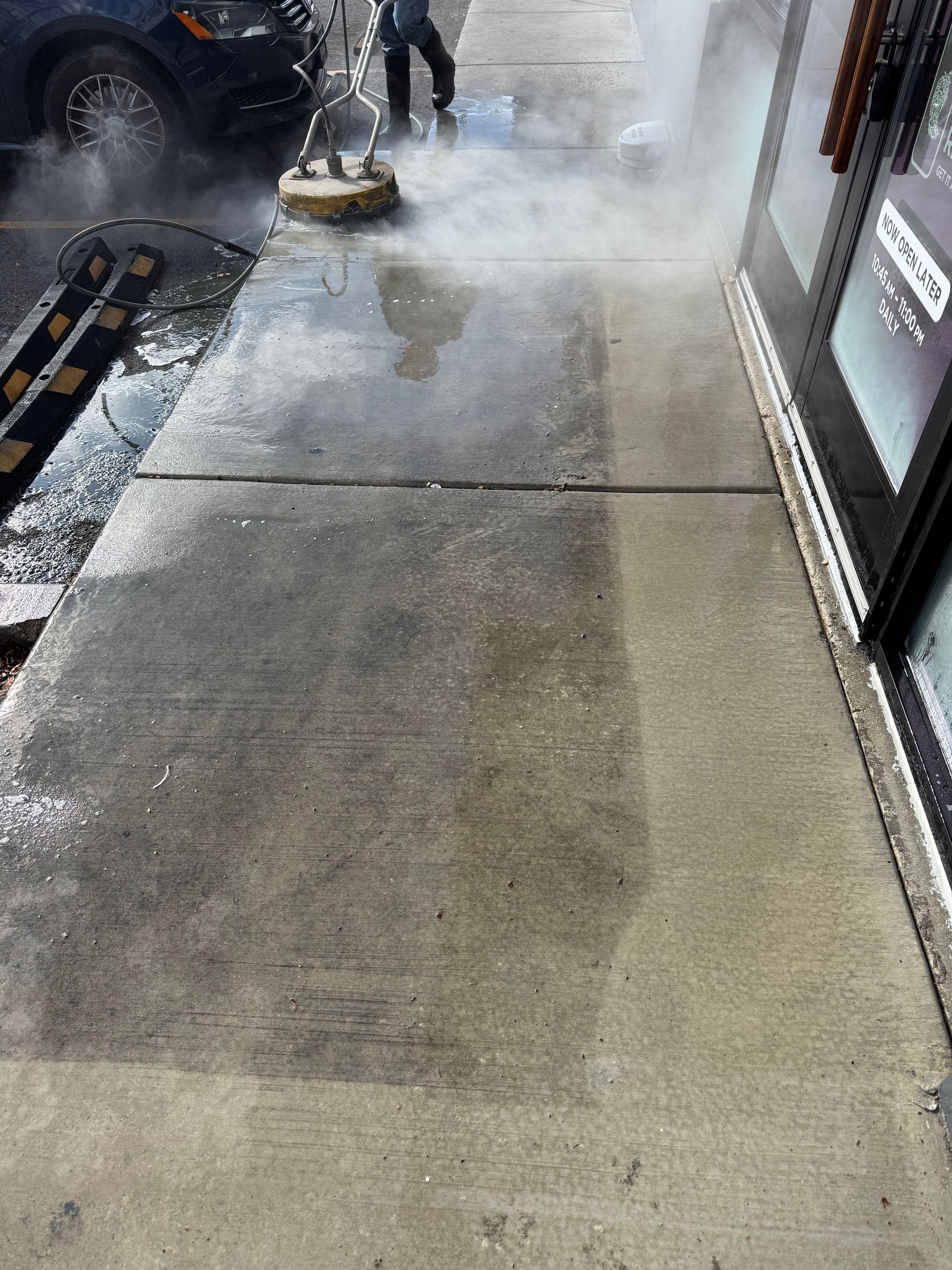 JET's high end surface cleaning system deep cleaning and sanitizing a concrete walkway for a restaurant.