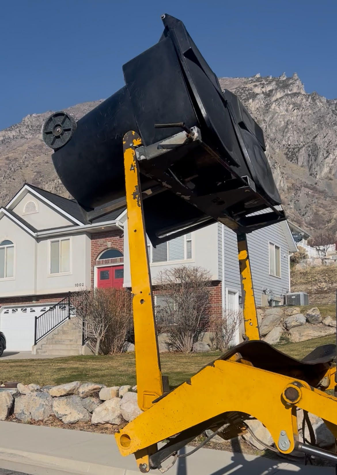 Garbage bins being lifted up to be deep cleaned by JET's specialized trash bin cleaning truck.