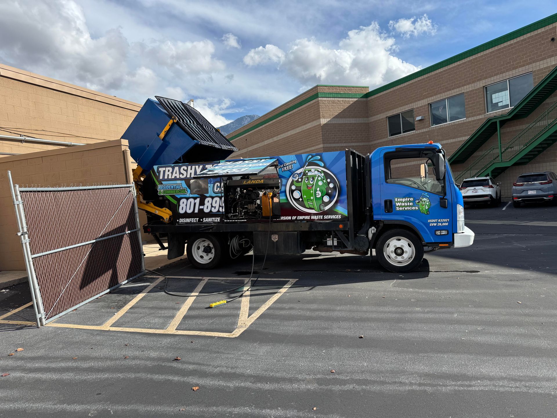 JET's specialized truck picking up a dumpster and deep cleaning it with high pressure 200 degree water