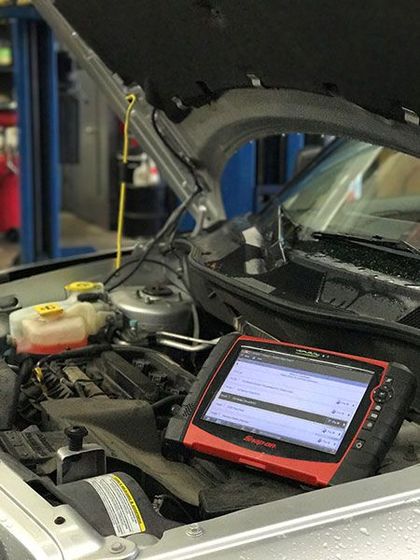 The hood of a car is open and a tablet is sitting underneath it. | The Garage in Renton