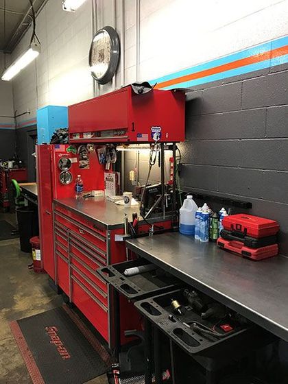 A workbench in a garage with tools and a clock on the wall. | The Garage in Renton