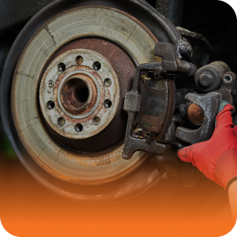 A person wearing a red glove is holding a brake caliper | The Garage in Renton