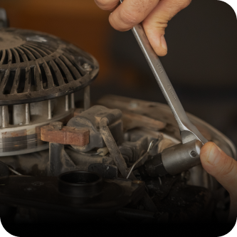 A person is working on a machine with a wrench | The Garage in Renton